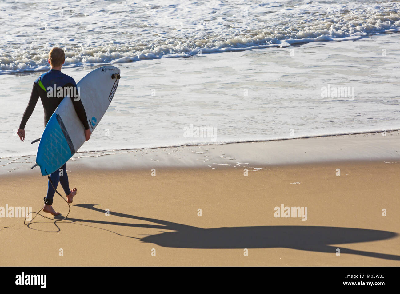 Bournemouth Dorset, Regno Unito. 18 gennaio, 2018. Regno Unito: meteo dopo una molto ventoso notte una bella giornata di sole a Bournemouth Beach. Surfer teste per il mare per rendere la maggior parte delle grandi onde e instabile dei mari. Surfer tenendo la scheda sulla riva del mare a piedi in mare e guardando le onde con ombra sulla sabbia. Credito: Carolyn Jenkins/Alamy Live News Foto Stock