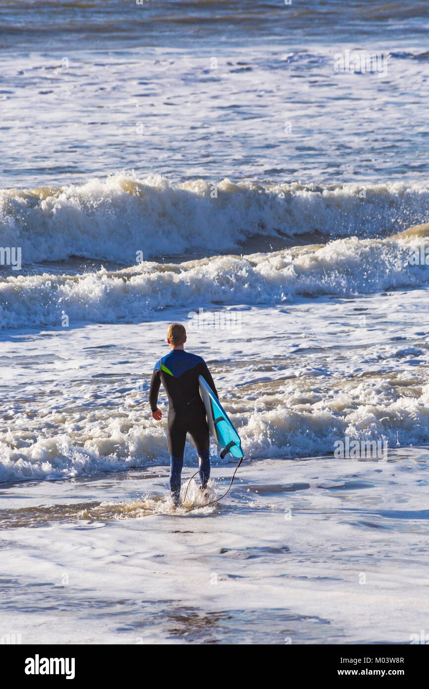 Bournemouth Dorset, Regno Unito. 18 gennaio, 2018. Regno Unito: meteo dopo una molto ventoso notte una bella giornata di sole a Bournemouth Beach. Surfer capi in mare per rendere la maggior parte delle grandi onde e instabile dei mari. Surfer tenendo la scheda Rubrica fuori in mare. Credito: Carolyn Jenkins/Alamy Live News Foto Stock