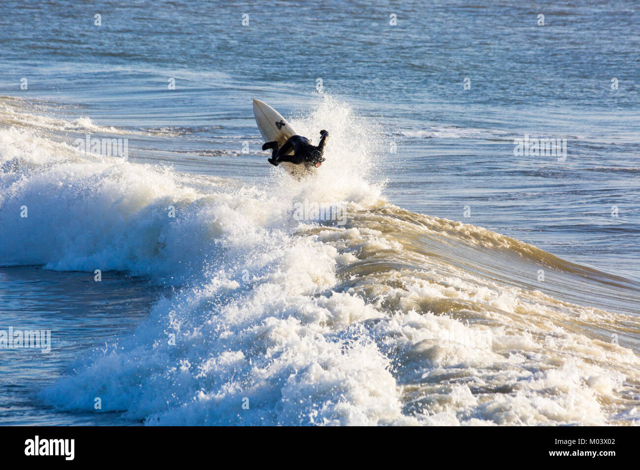 Bournemouth Dorset, Regno Unito. 18 gennaio, 2018. Regno Unito: meteo dopo una molto ventoso notte una bella giornata di sole a Bournemouth Beach. Surfers rendono la maggior parte delle grandi onde e instabile dei mari. Surfer cavalcare un onda andando fino all'aria. Credito: Carolyn Jenkins/Alamy Live News Foto Stock