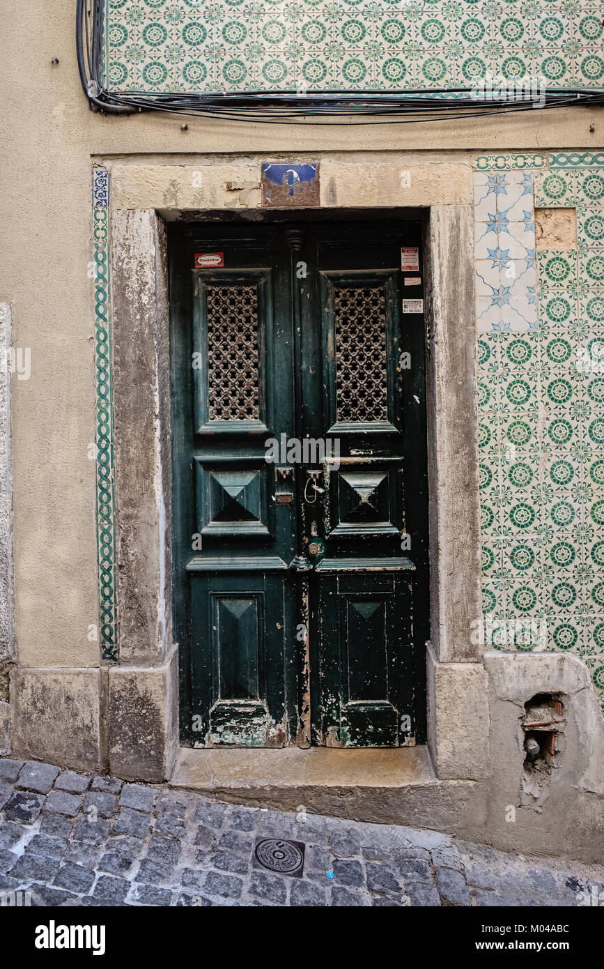 Bella porta circondato dalla piastrella tradizionale a Lisbona, Portogallo Foto Stock