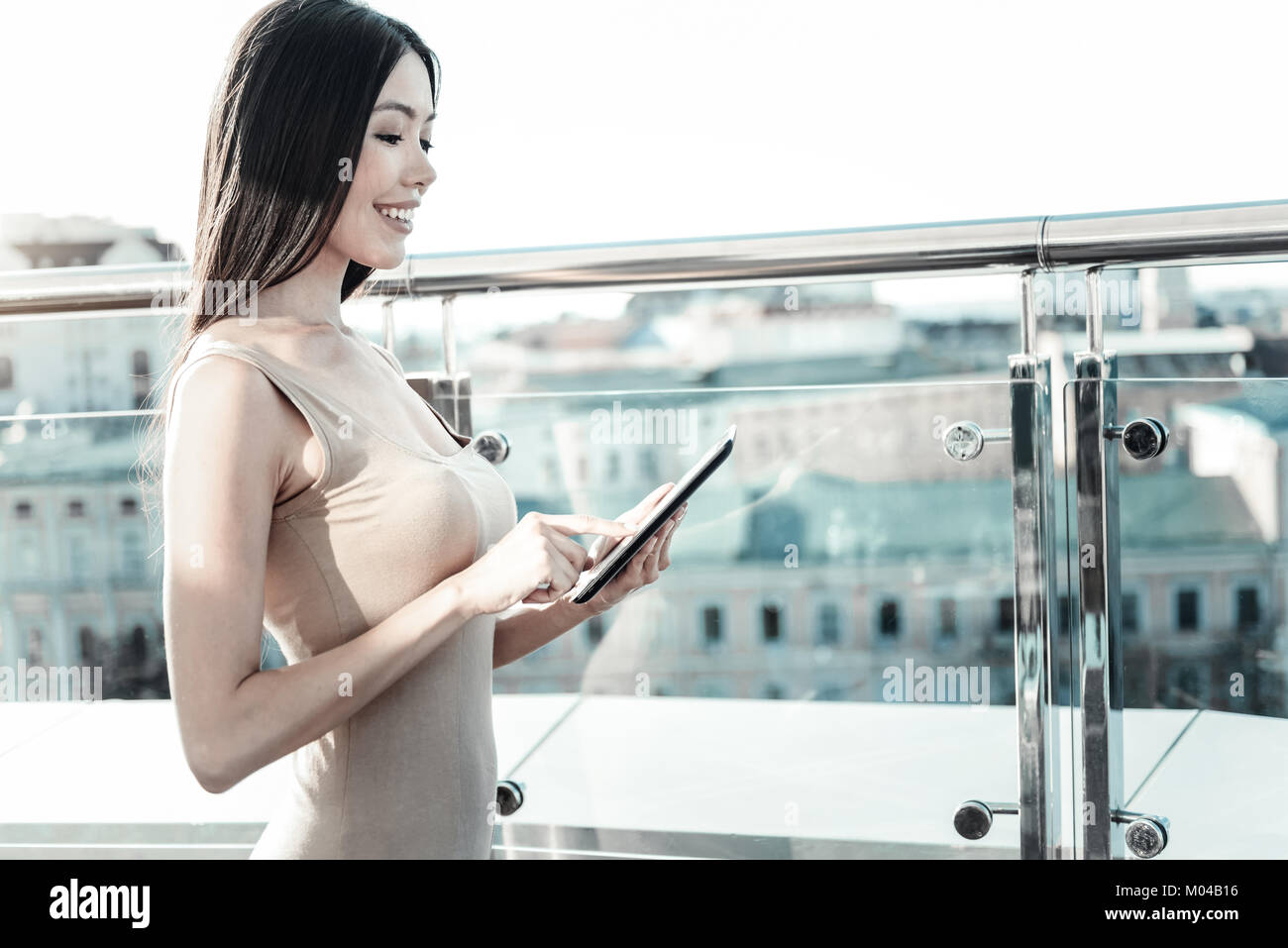 Smart carino lady in piedi e utilizzando il tablet. Foto Stock