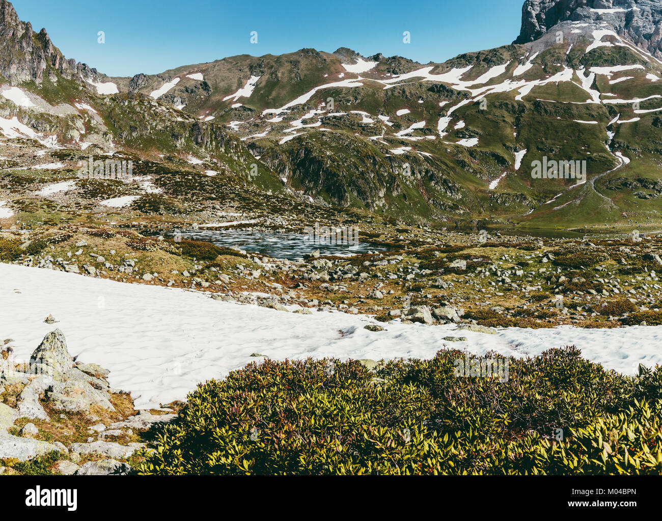 Paesaggio di montagna in estate, tranquilla idilliaco paesaggio di verde radure, picchi e piste innevate e. Stile di vita il turismo e viaggi avventura. Alpine vista rocciose Foto Stock