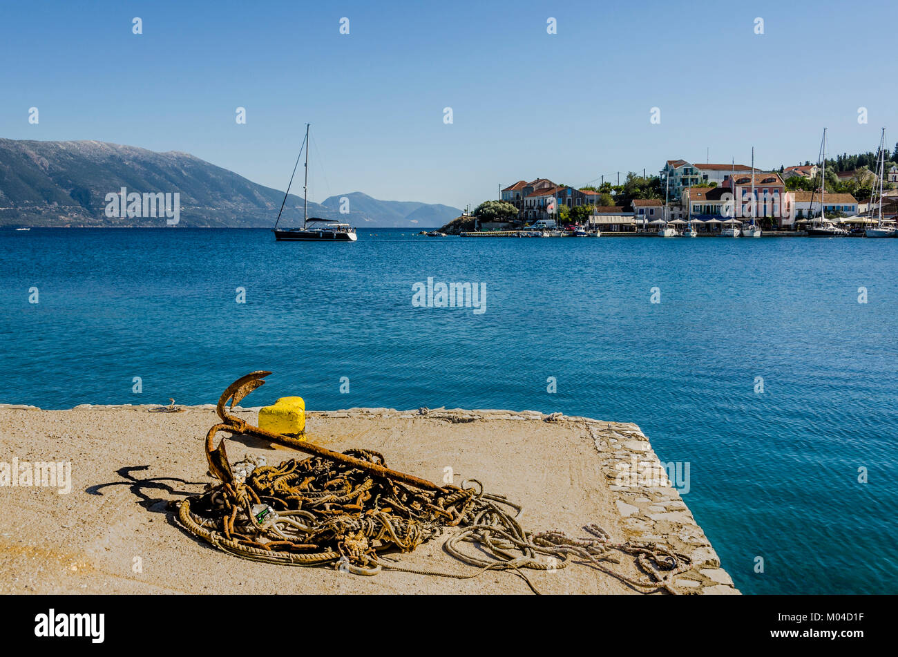 Molo di fiskardo villaggio sul mare ionico close-up di funi di ancoraggio e arrugginito sul molo di Baia di fyskardo barche edifici e infine il Foto Stock