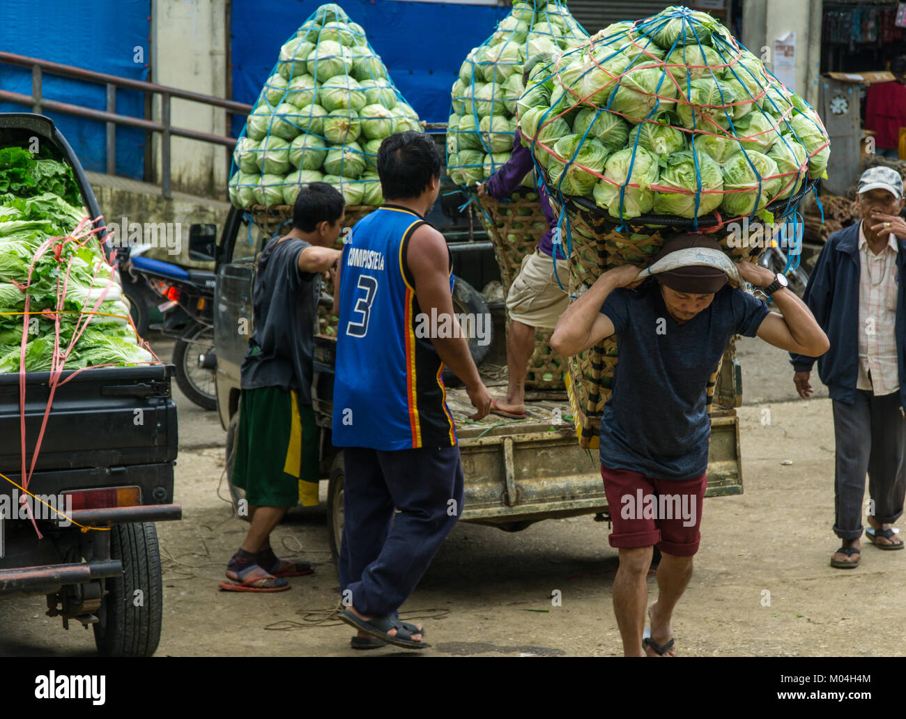 Portieri di mercato il trasferimento di carichi molto pesanti di verdura,Mantalongon mercato,Dalaguete,Cebu Foto Stock