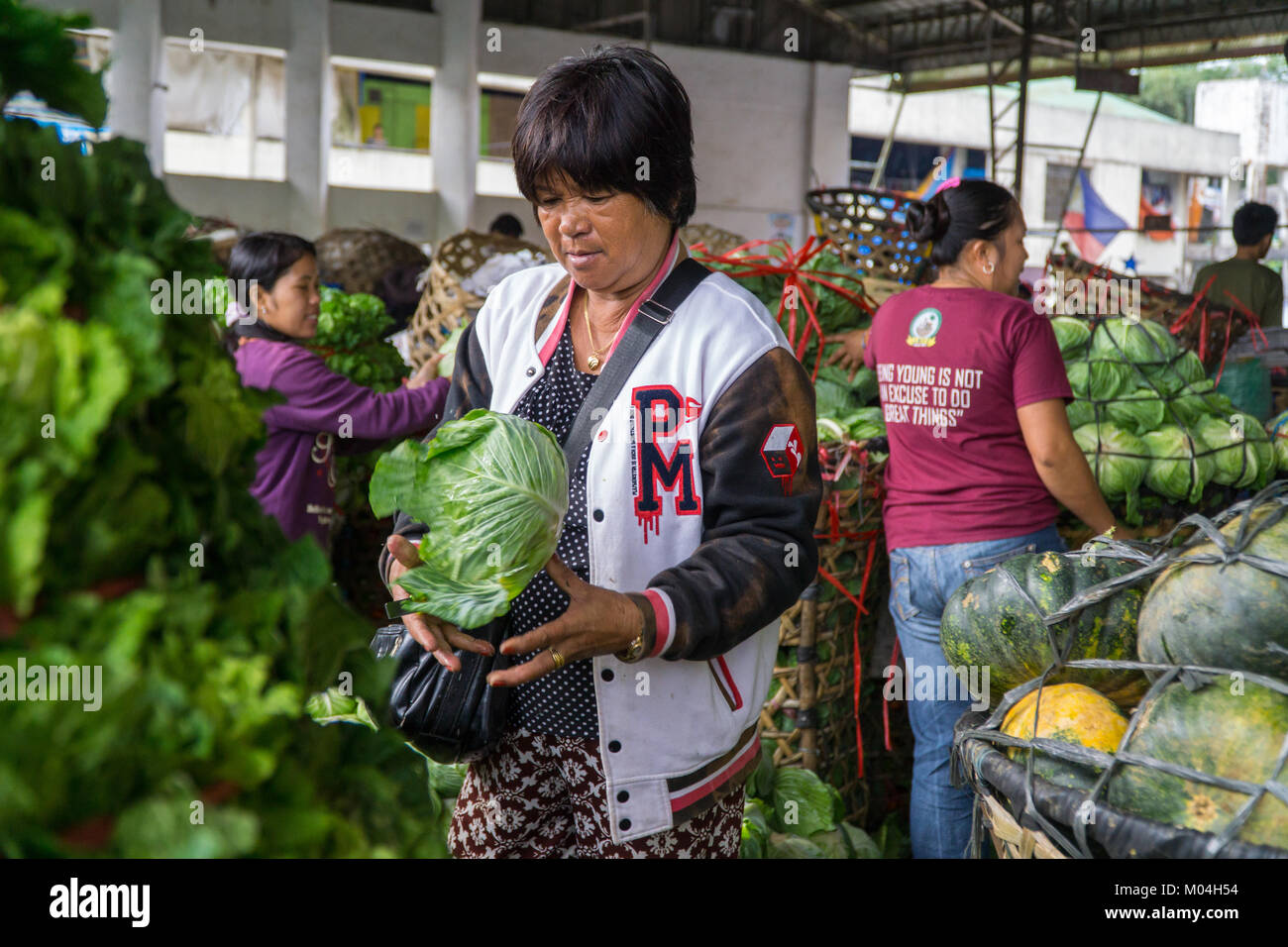 Traders ordina & re-pack verdure portato dalle zone di montagna,Mantalongon mercato,Dalaguete,Cebu. Foto Stock