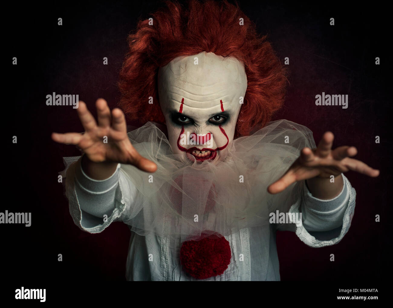 Ragazzo vestito come un clown su sfondo nero boy vestito come un clown su sfondo nero Foto Stock