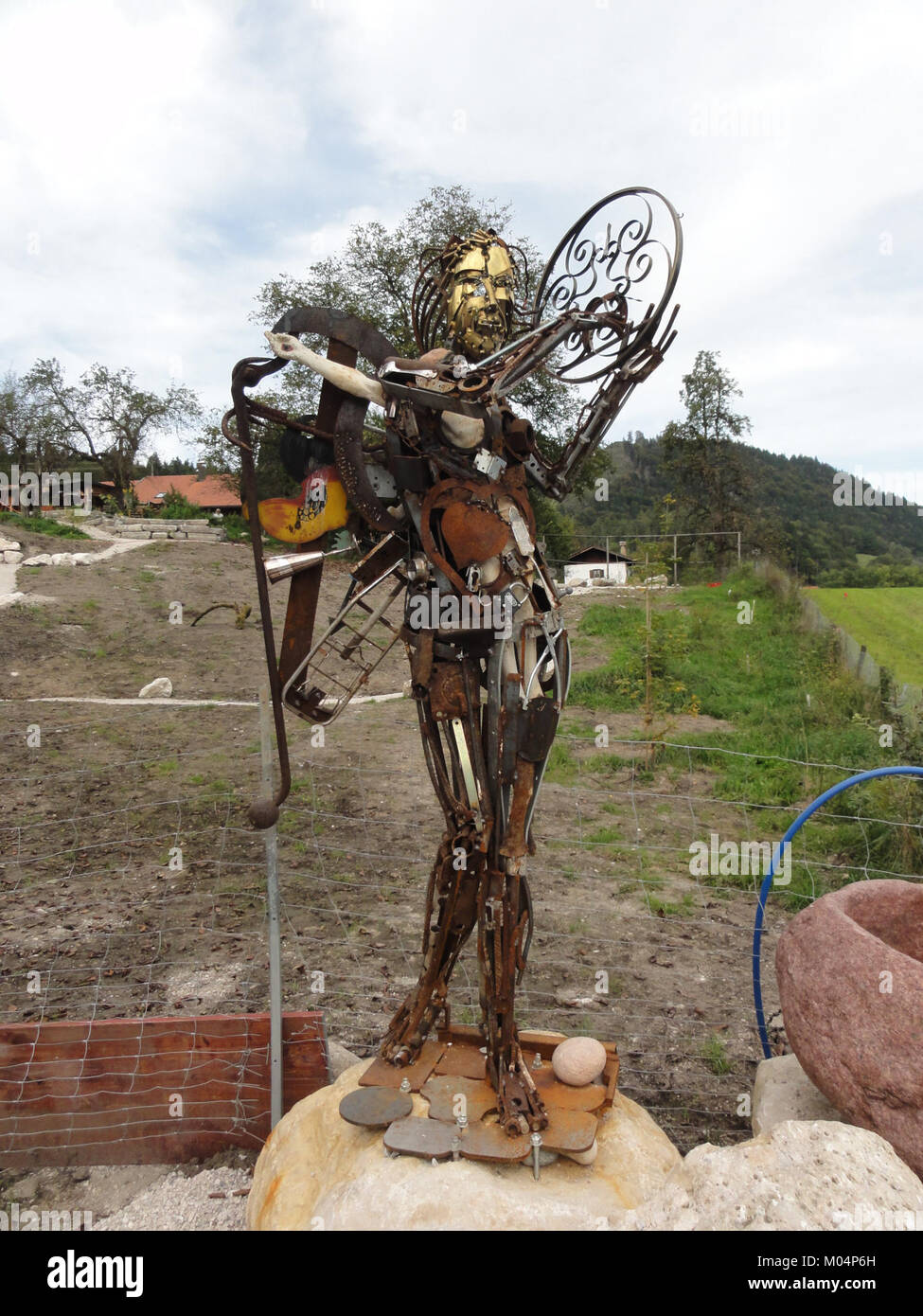 Questa scultura di Breitenau, Kiefersfelden, è stata creata da pezzi di ferro, che mostrano arte industriale in un ambiente naturale. Foto Stock