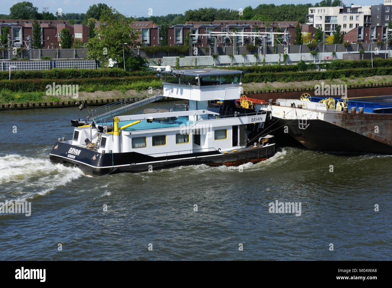Il Bryan (ENI 06105041) è un rimorchiatore che spinge la Barge Slinge (ENI 02334956) lungo il canale Amsterdam-Rijn nei Paesi Bassi, fondamentale per il trasporto lungo questo importante corso d'acqua. Foto Stock