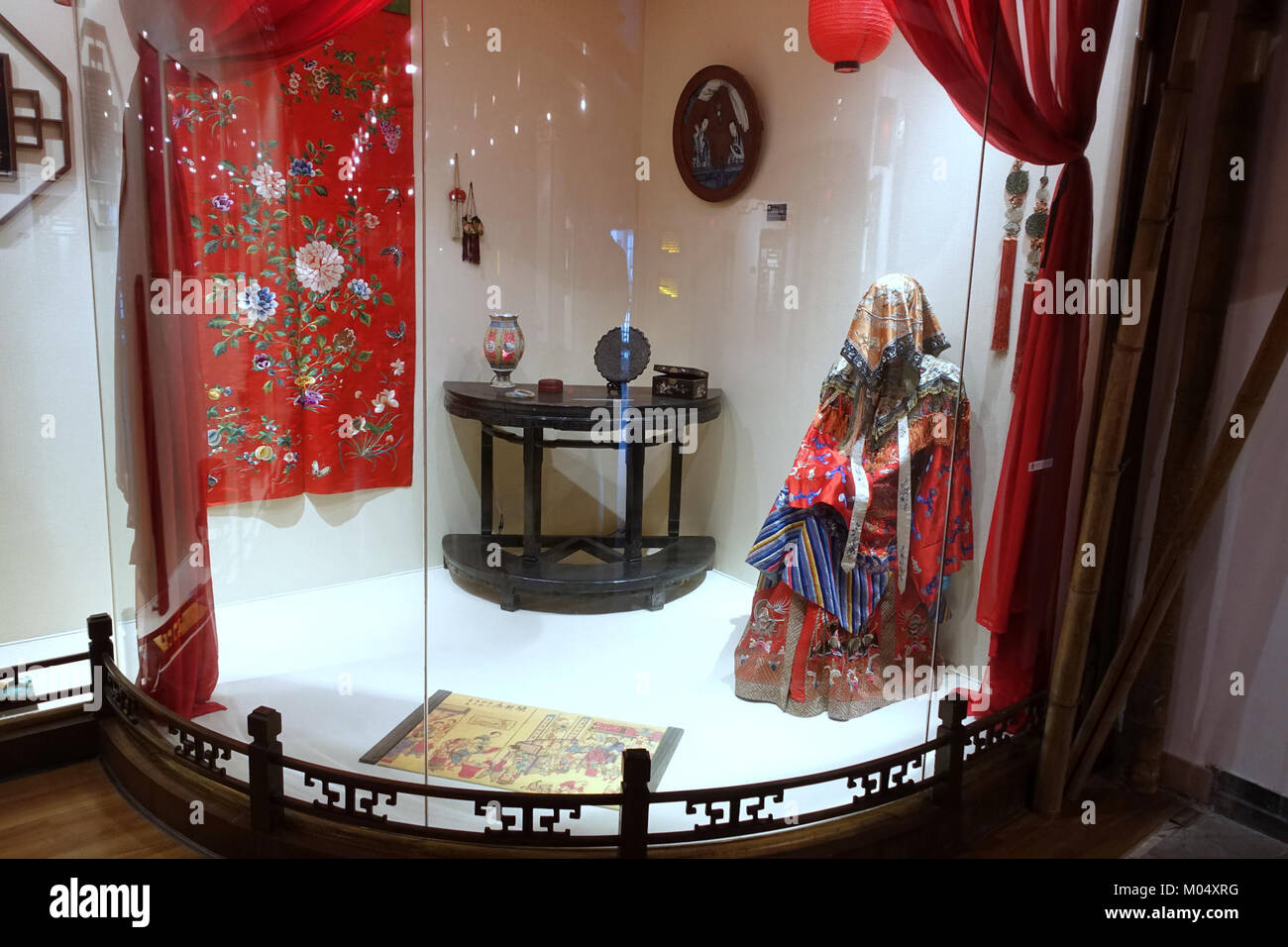 Una scena nuziale catturata al Museo dell'Università di Sichuan a Chengdu, Cina. L'immagine raffigura abiti tradizionali ed elementi culturali in un ambiente museale. Riflette il significato dei rituali e delle usanze nuziali, mostrando il patrimonio e la storia locale attraverso una narrazione visiva. Foto Stock