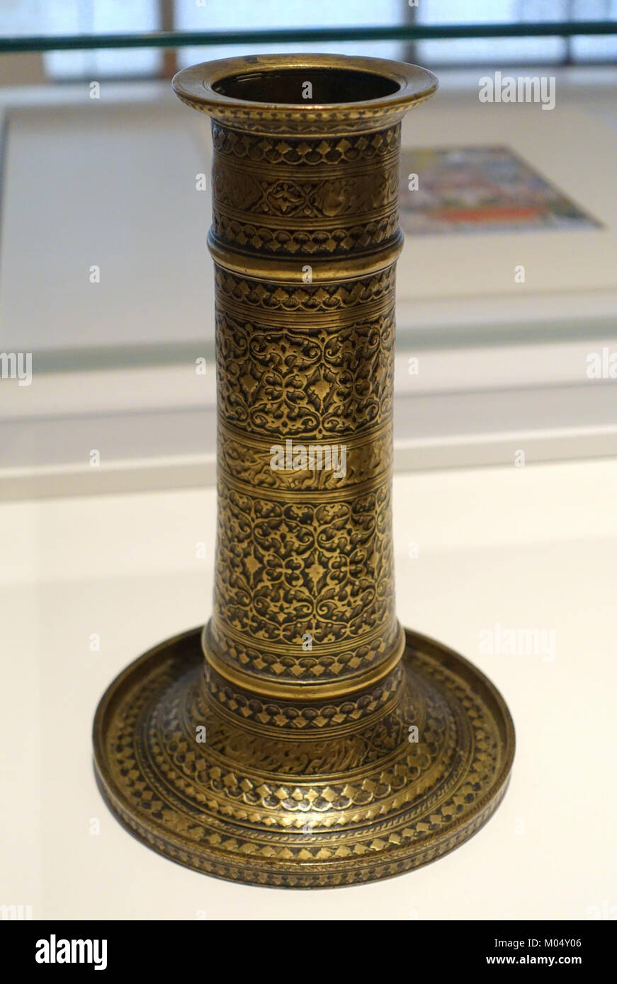 Questo candelabro, datato 1617-1618 d.C., presenta accoppiamenti persiani ed è realizzato in ottone intarsiato con composto nero. Rappresenta la raffinata lavorazione dei metalli e la calligrafia dell'epoca Moghul, attualmente ospitata nel Museo Aga Khan di Toronto. Foto Stock