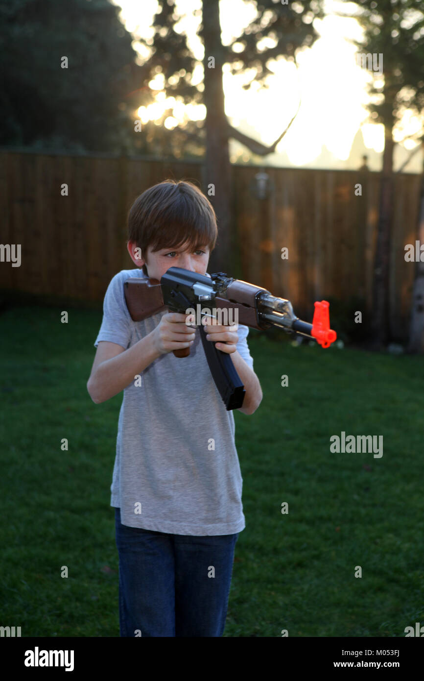Ragazzo sparare pistola giocattolo Foto Stock