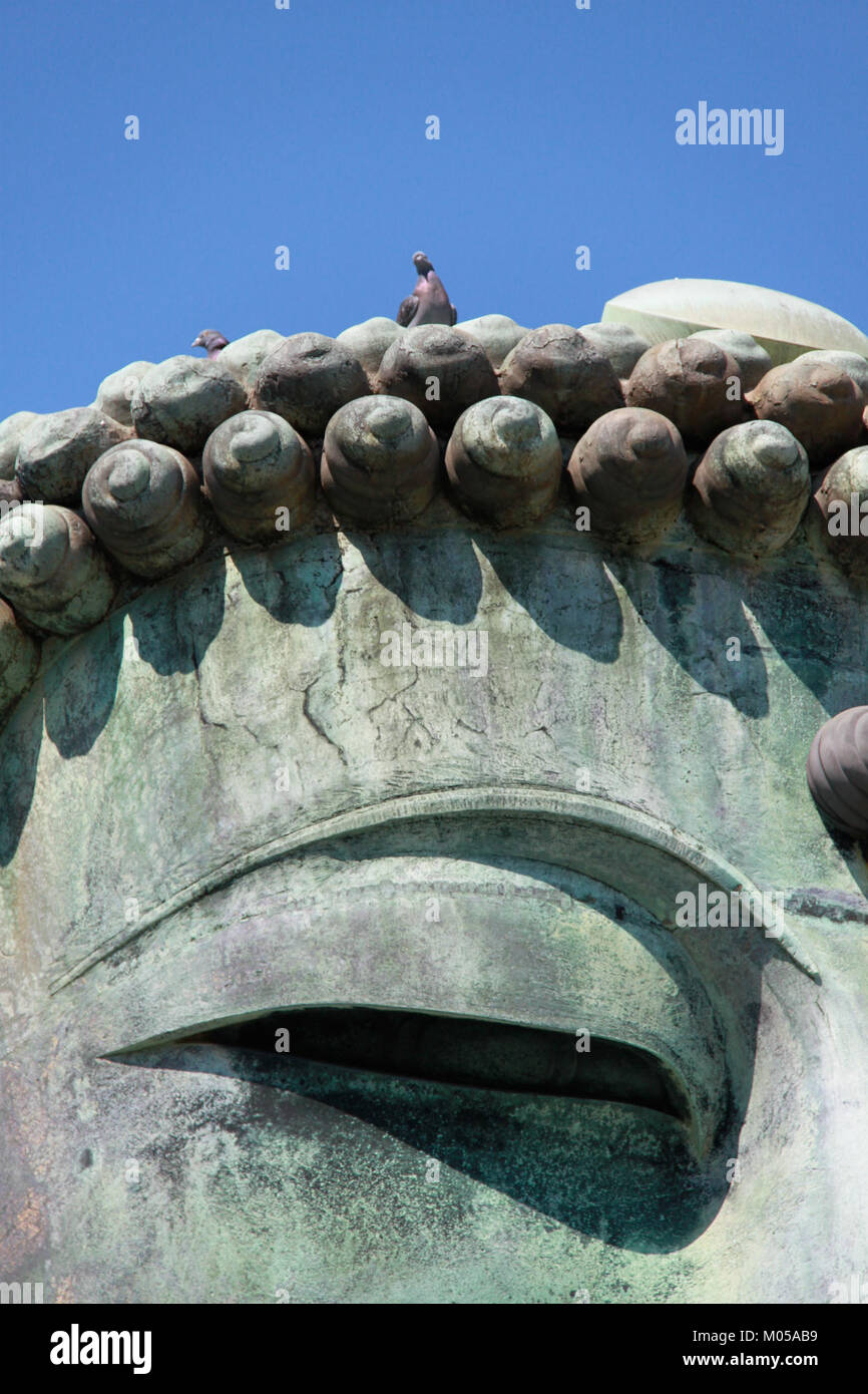 Una vista ravvicinata della statua del Buddha a Kamakura, in Giappone, uno dei monumenti più rappresentativi della regione. La statua, realizzata in bronzo, rappresenta gli insegnamenti buddisti e riflette la storia religiosa e l'artigianato del Giappone. Foto Stock