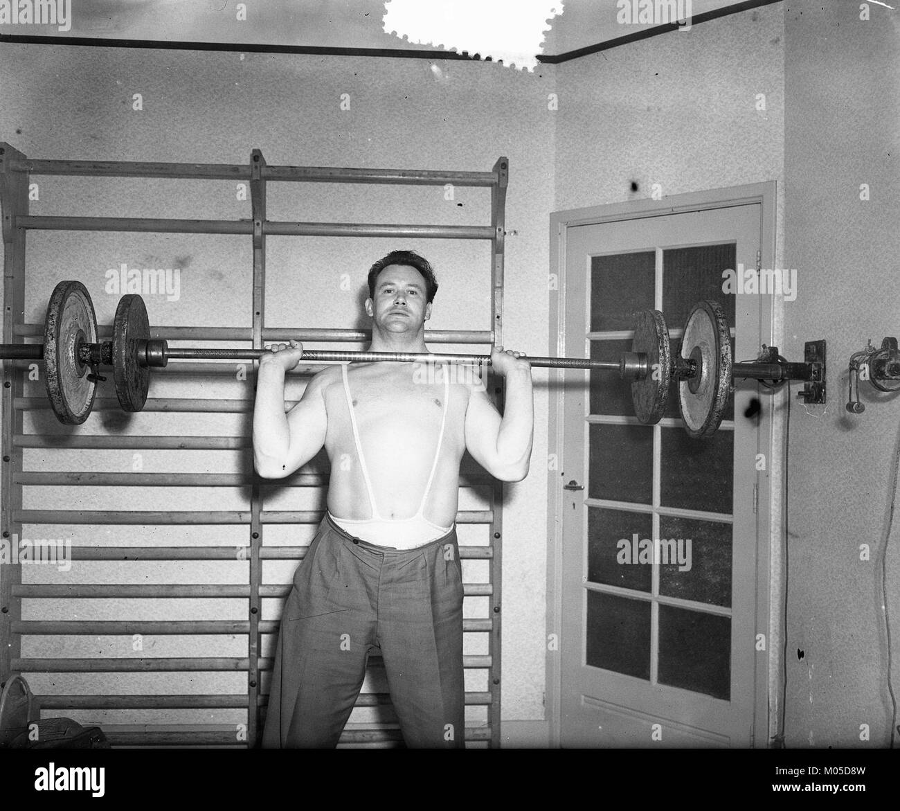 Il sollevatore olandese Bram Charité è stato catturato in azione durante i Campionati mondiali di sollevamento pesi 1952, dove ha conquistato la medaglia di bronzo nella categoria dei pesi leggeri maschile. Questa fotografia, scattata il 10 aprile 1952, dal fotografo Van Duinen per l'agenzia di stampa nazionale olandese Anefo, è conservata nel Nationaal Archief (Archivi nazionali) sotto l'identificatore Bestanddeelnr 905-0476. Foto Stock
