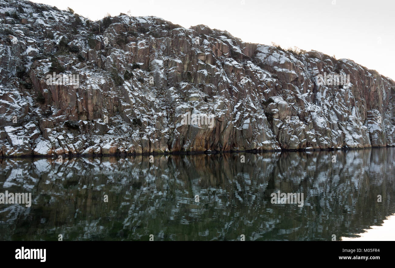 Brofjorden, situato in Svezia, offre una vista mozzafiato delle scogliere innevate di Loddebo. Questa immagine cattura la bellezza naturale e l'aspro paesaggio caratteristico della costa svedese. Foto Stock