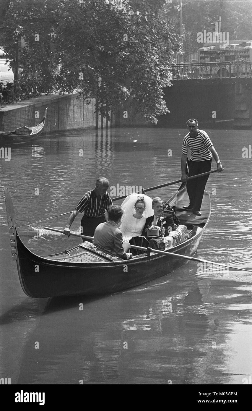 Questa immagine raffigura una coppia, Klene Van Stelten, che fa un giro in gondola attraverso i canali di Amsterdam. La foto cattura un momento romantico lungo i famosi corsi d'acqua della città. Foto Stock