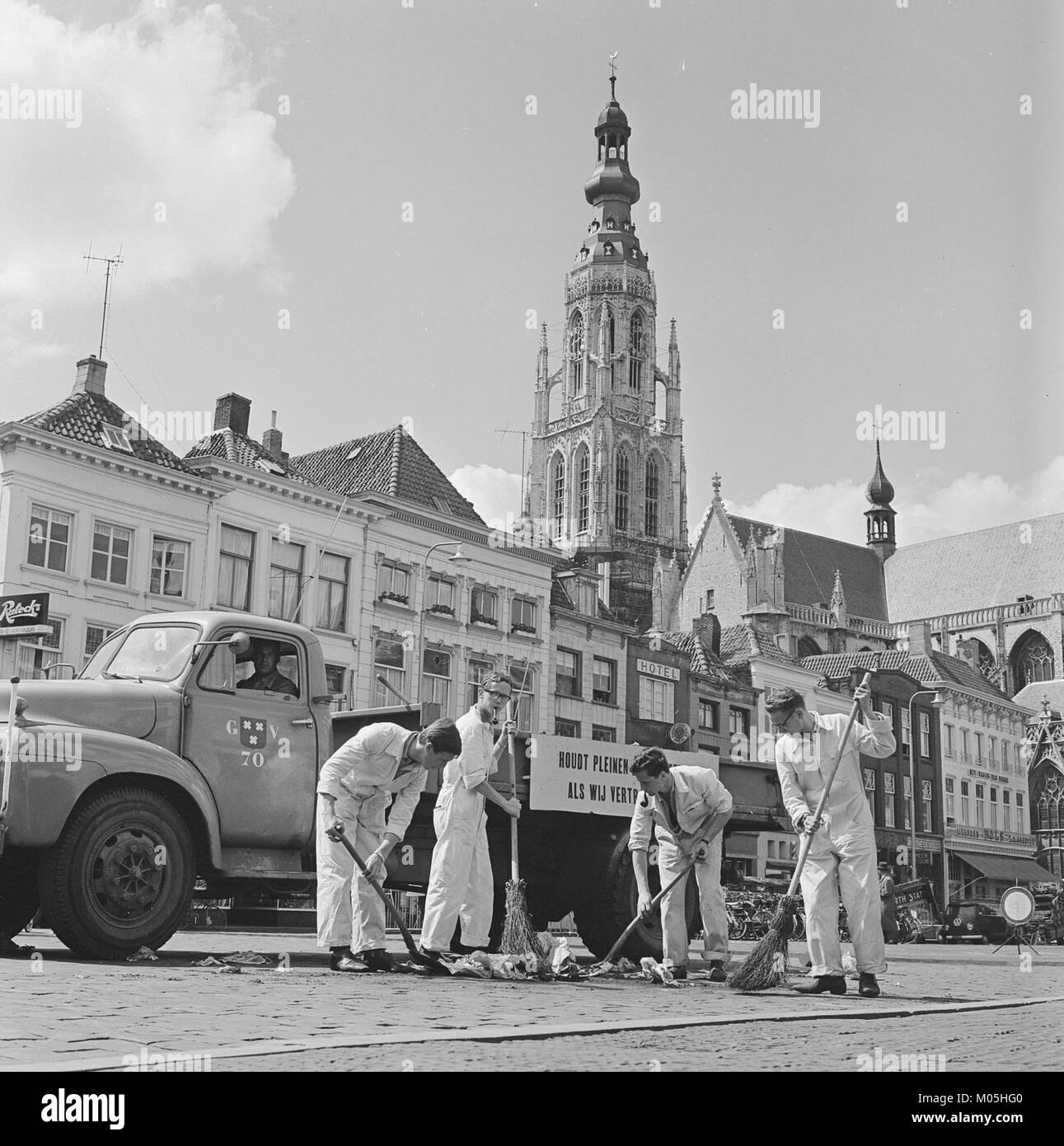 Un giovane a Breda che lavora come spazzatrice di strada come parte di un lavoro estivo. L'immagine cattura l'occupazione urbana e gli sforzi di manutenzione pubblica. Foto Stock