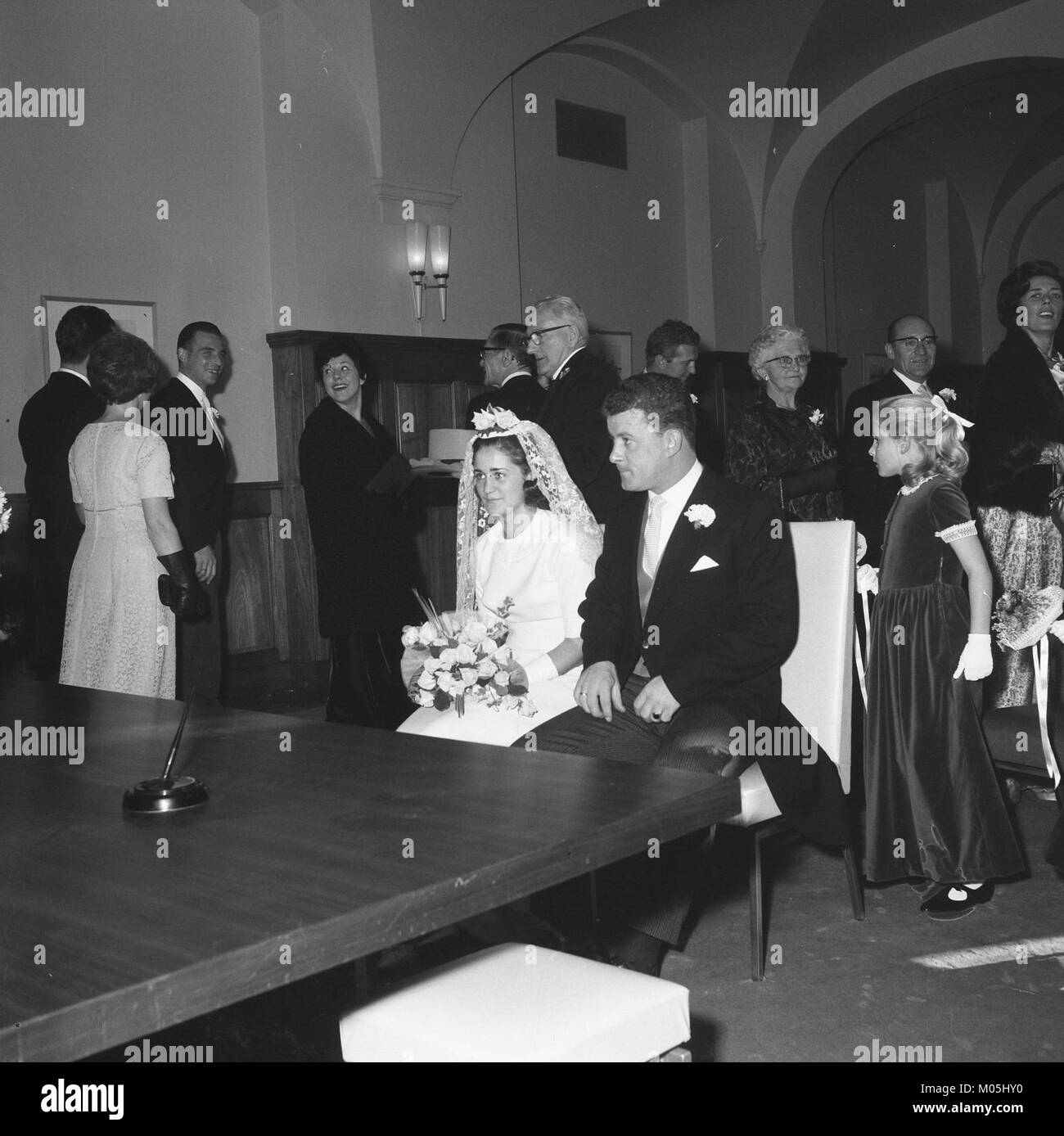 Questa immagine, intitolata "Bruidspaar in de trouwzaal" (Sposa e sposo nella sala matrimoni), cattura un momento di una celebrazione nuziale nei Paesi Bassi, illustrando le tradizioni matrimoniali olandesi. Foto Stock
