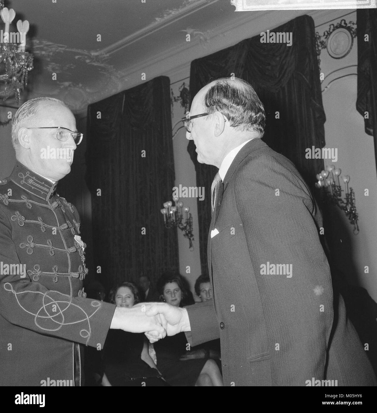 Questa immagine raffigura l'ambasciatore britannico che presenta onorificenze ai cittadini olandesi durante la settimana britannica. L'evento mette in luce le relazioni diplomatiche e culturali tra Regno Unito e Paesi Bassi. Foto Stock