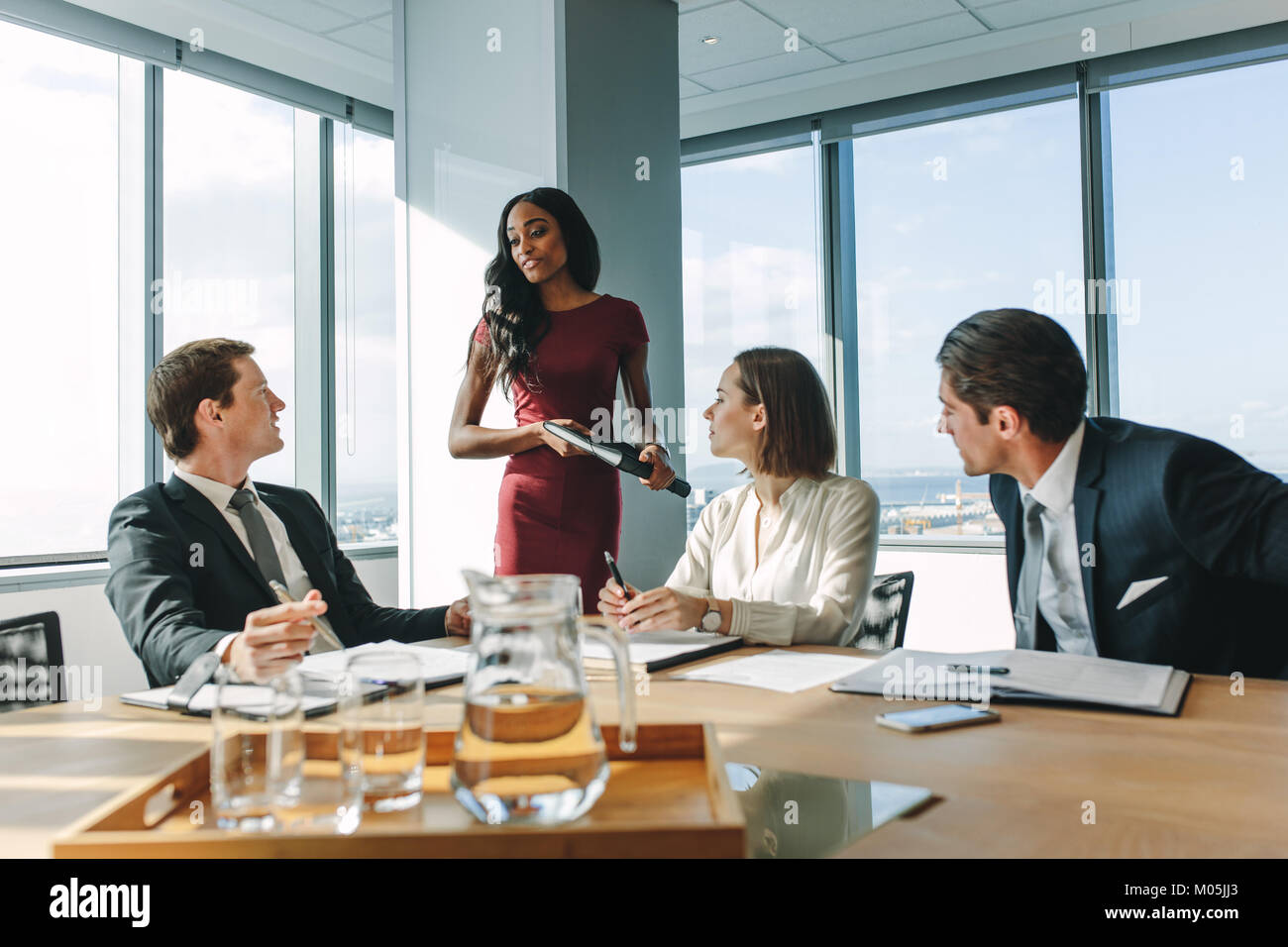 Executive femmina di mettere le sue idee durante la riunione in sala riunioni. Gruppo di business persone aventi una riunione nella sala conferenze. Foto Stock