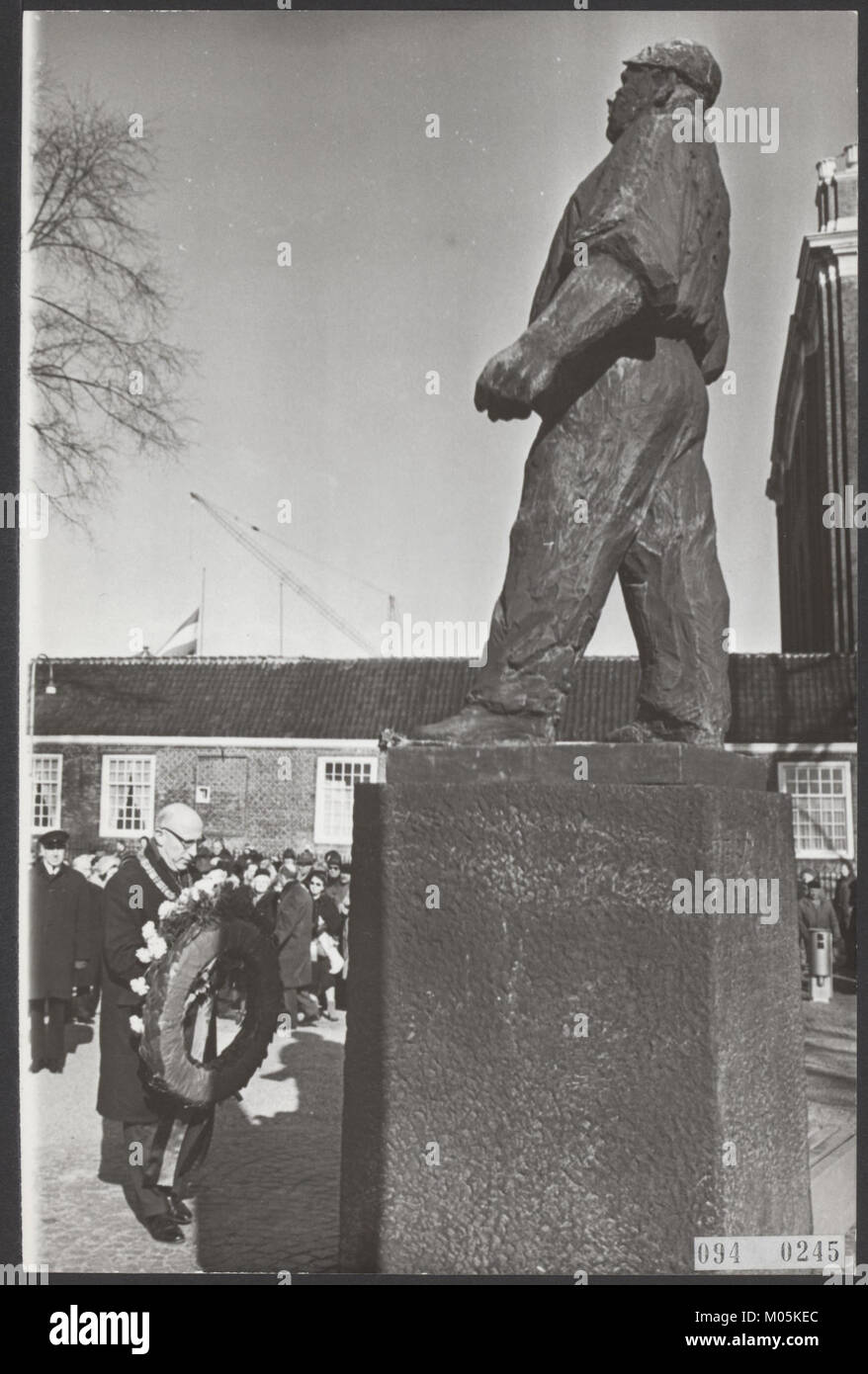 Burgemeester Samkalden posa una corona presso il monumento Dokwerker su J.D. Meijerplein ad Amsterdam. Questo evento probabilmente onora il significato storico del monumento, che rappresenta la resistenza olandese durante la seconda guerra mondiale. Foto Stock