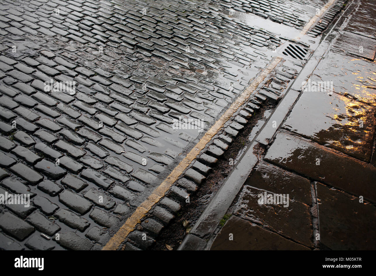 Manchester strada di ciottoli sotto la pioggia Foto Stock