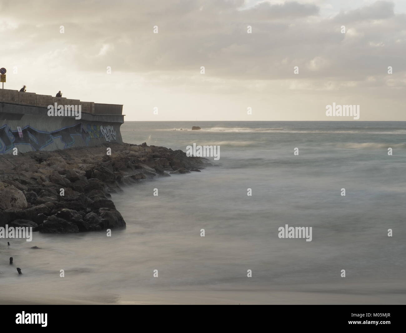 In movimento e le onde che si infrangono sulle rocce della costa Foto Stock