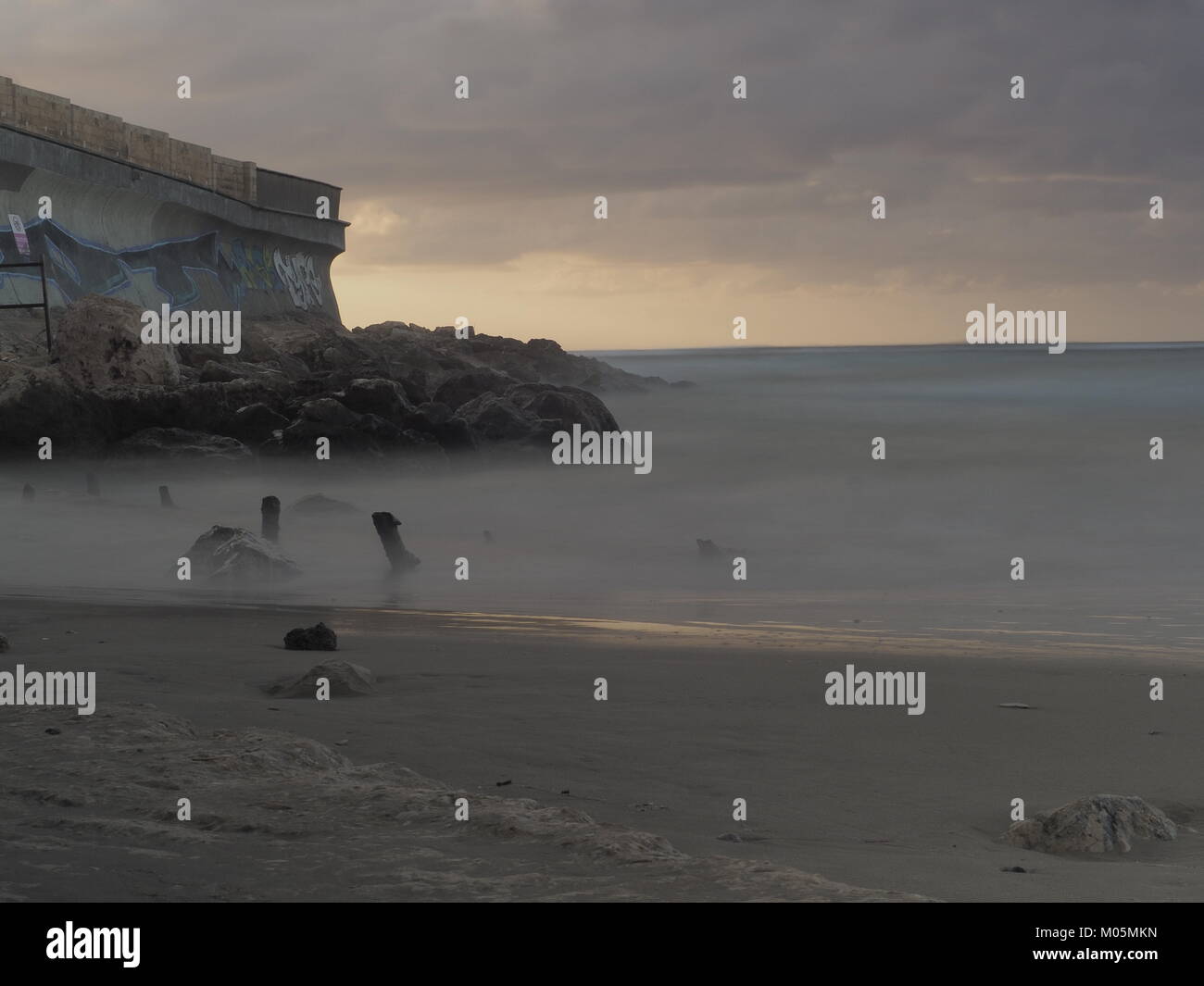 In movimento e le onde che si infrangono sulle rocce della costa Foto Stock