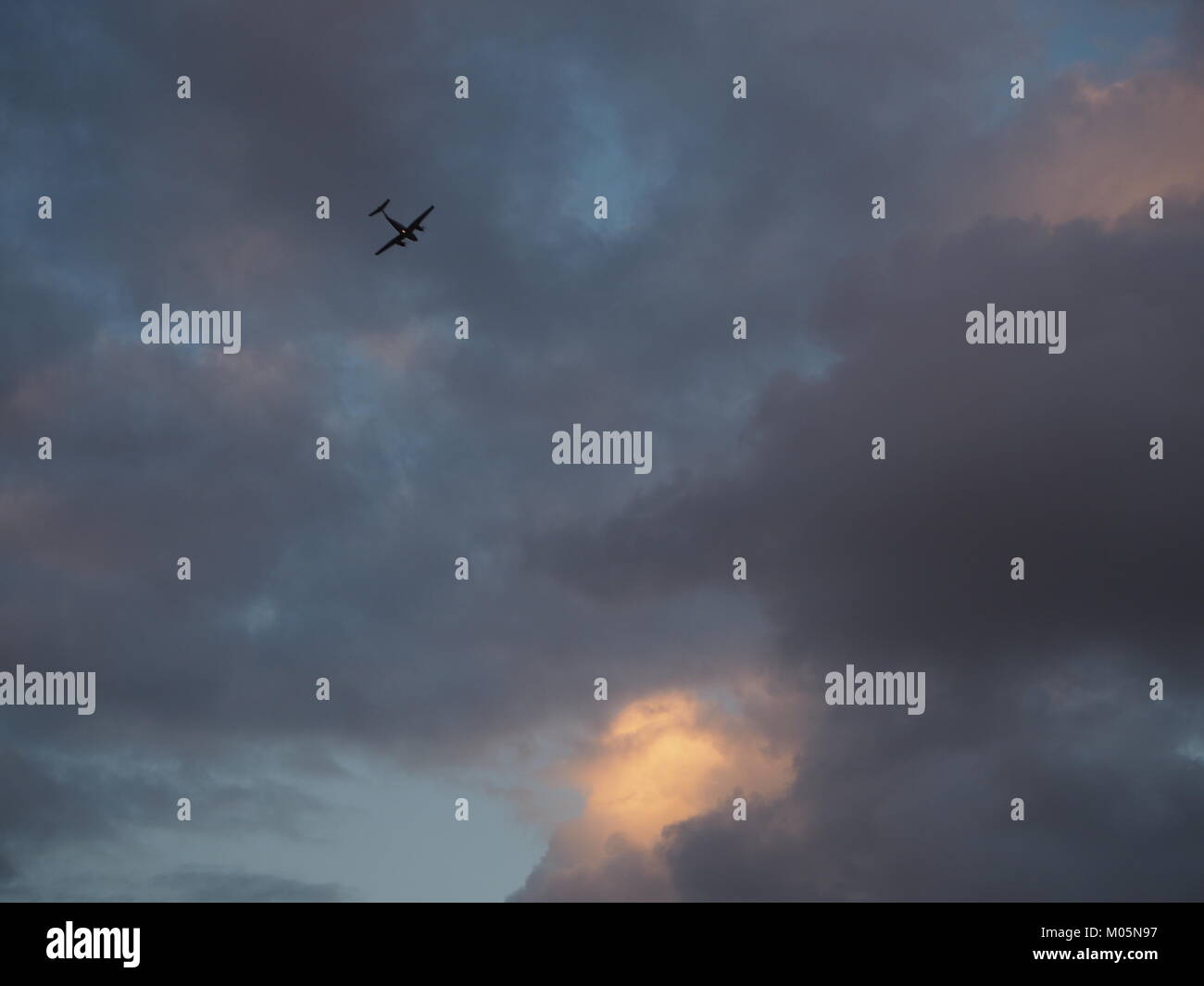 Un aereo ovest alla sera rebbio sul grigio di un cielo nuvoloso Foto Stock