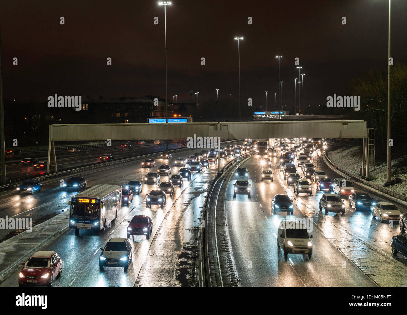 Vista notturna di traffico su autostrada M8 durante le giornate di cattivo tempo nella zona centrale di Glasgow, Scotland, Regno Unito. Foto Stock