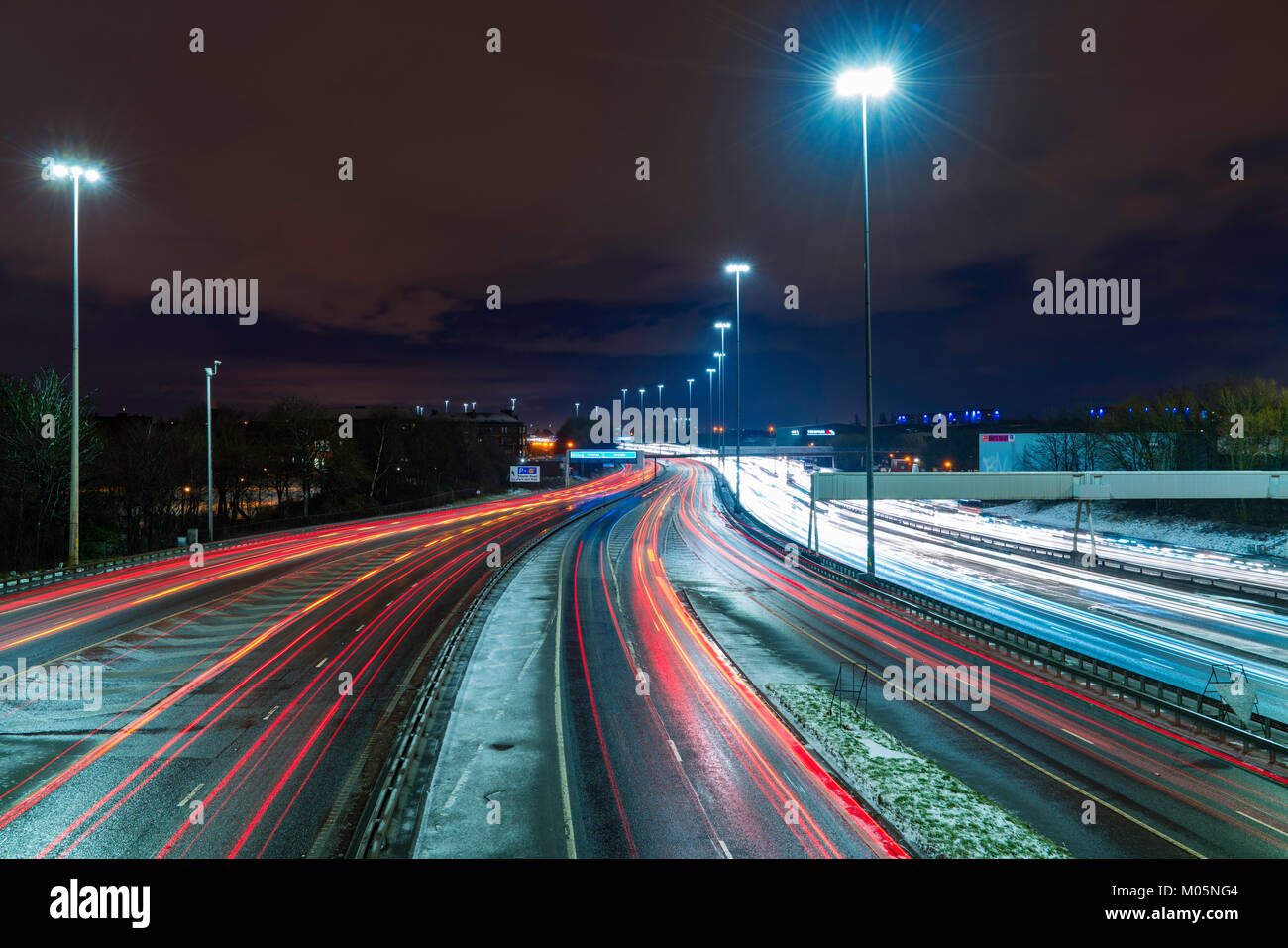 Vista notturna di traffico su autostrada M8 durante le giornate di cattivo tempo nella zona centrale di Glasgow, Scotland, Regno Unito. Foto Stock