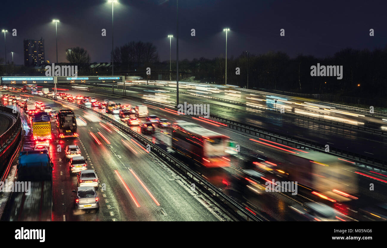 Vista notturna di traffico su autostrada M8 durante le giornate di cattivo tempo nella zona centrale di Glasgow, Scotland, Regno Unito. Foto Stock