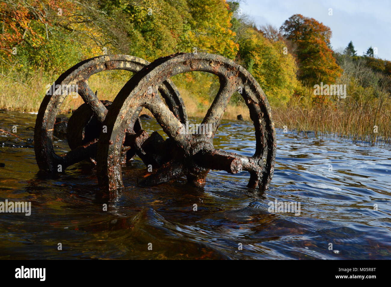 Metallo arrugginito ruote in un lago Foto Stock