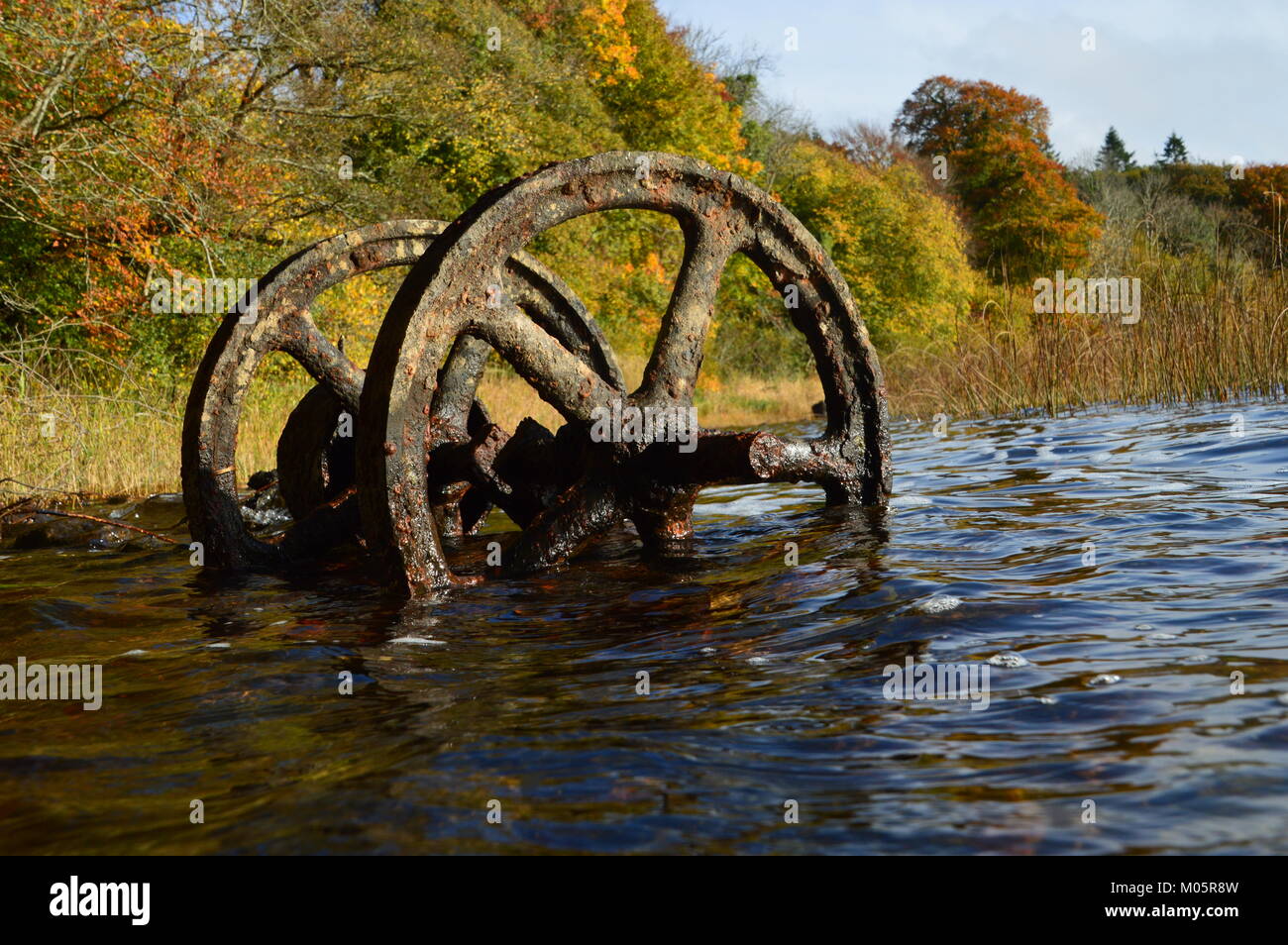 Metallo arrugginito ruote in un lago Foto Stock