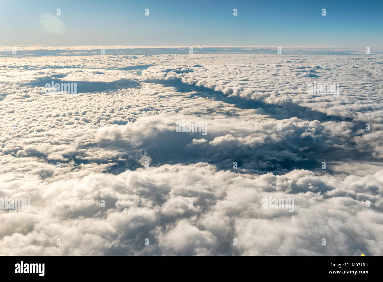 Viaggio in aereo. Vista attraverso una finestra di aereo. Sorvolando cirrus e cumuli di nuvole con poca turbolenza, mostra atmosfera della terra. Foto Stock