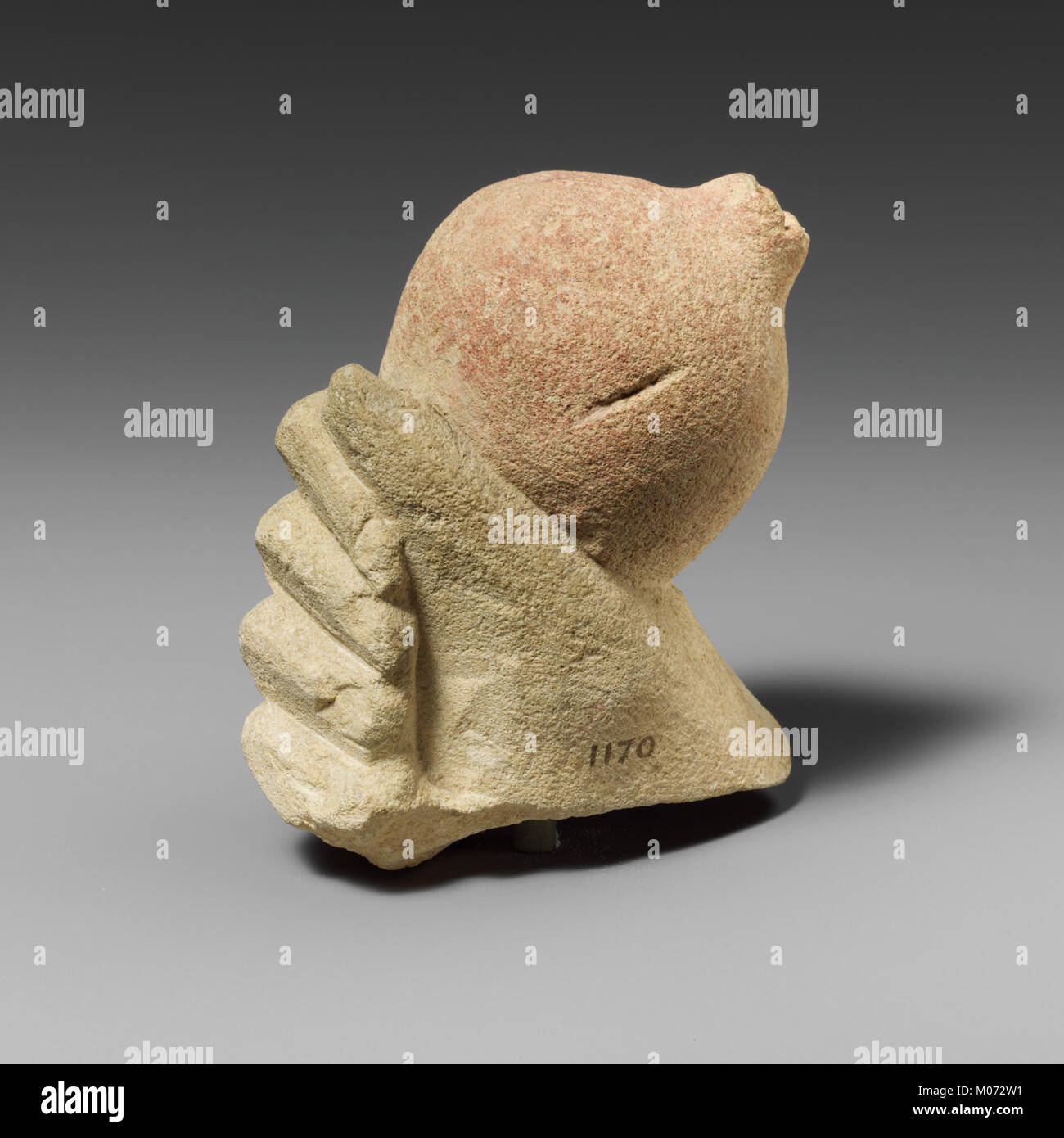 Questa scultura in pietra calcarea raffigura una mano che tiene un melograno, simboleggia la fertilità e l'abbondanza, riflettendo la tradizione scultorea classica e l'artigianato, parte della collezione MET. Foto Stock
