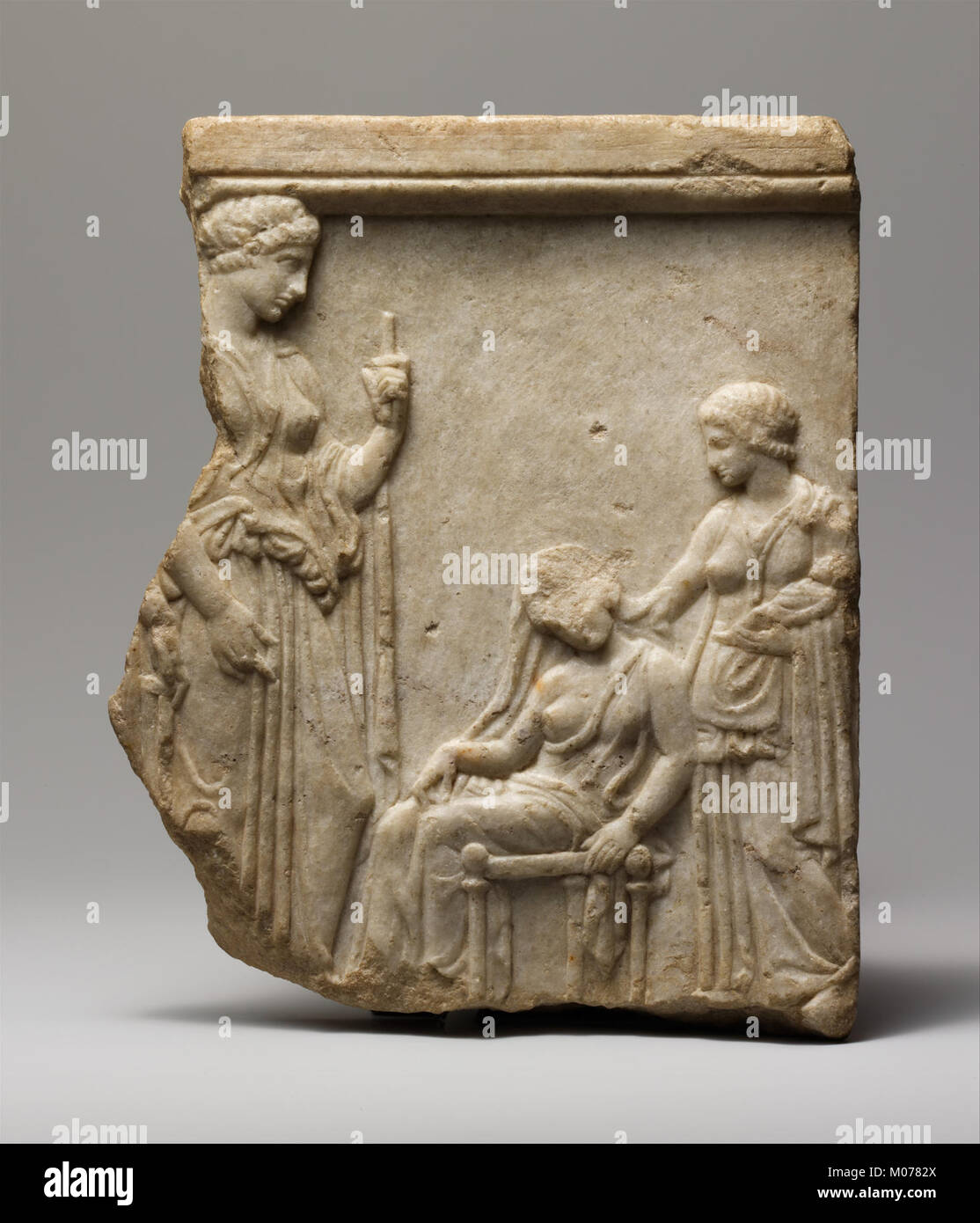 Questo frammento votivo in marmo raffigura le dee, tra cui figure di madre, infermiera e neonati, che illustrano la fertilità, nutrire e proteggere la divinità nell'arte religiosa. Foto Stock