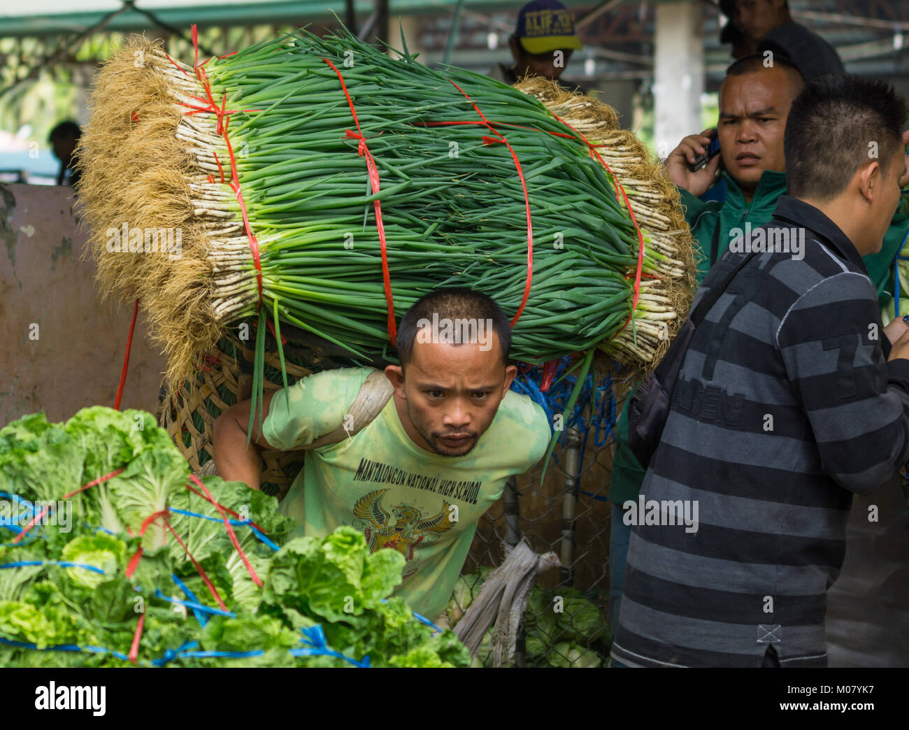 Portieri di mercato il trasferimento di carichi molto pesanti di verdura,Mantalongon mercato,Dalaguete,Cebu Foto Stock