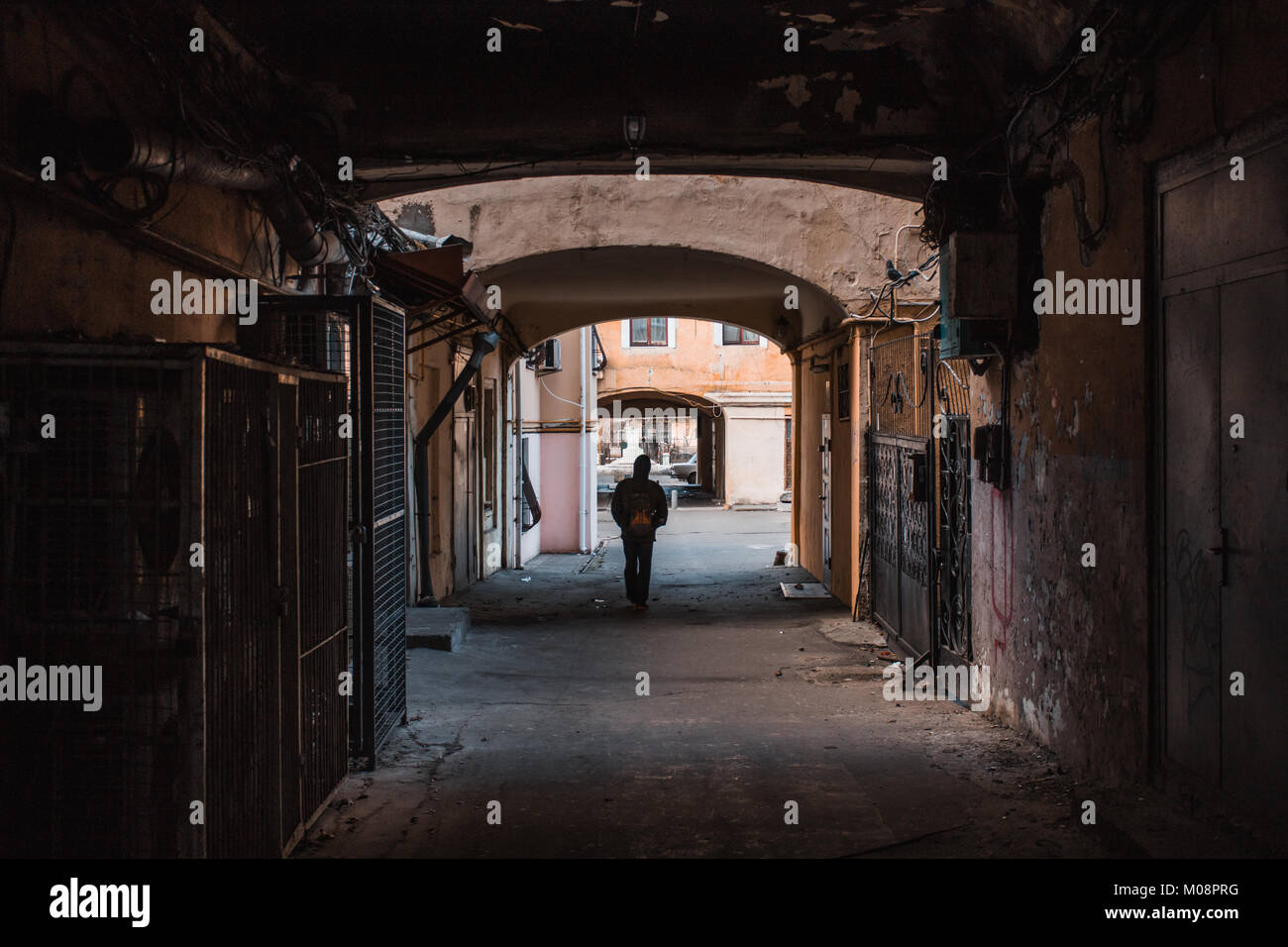 Uomo che cammina da solo attraverso il vecchio passaggio a Odessa, Ucraina. Foto Stock