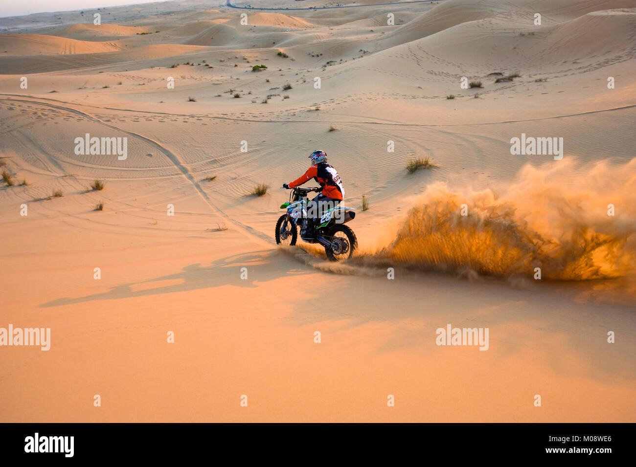 ABU DHABI, Emirati Arabi Uniti - 01 GEN 2018: un uomo su un dirt bike è a cavallo sulle colline nel deserto negli Emirati Arabi Uniti. Foto Stock