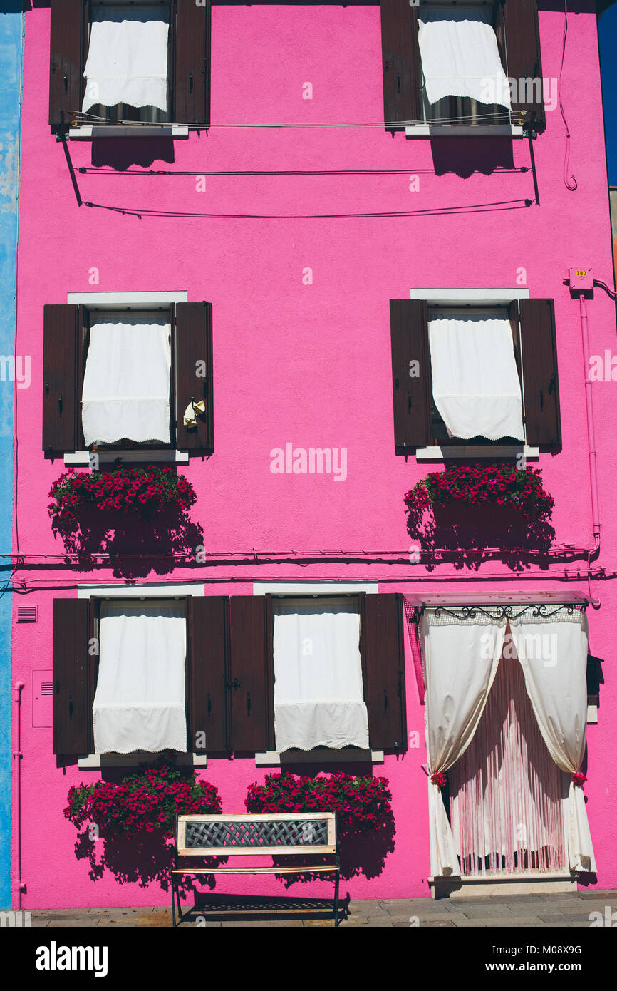 Rosa un muro di una casa residenziale con le finestre chiuse durante la bassa stagione in isola di Burano, Venezia, Italia. Foto Stock