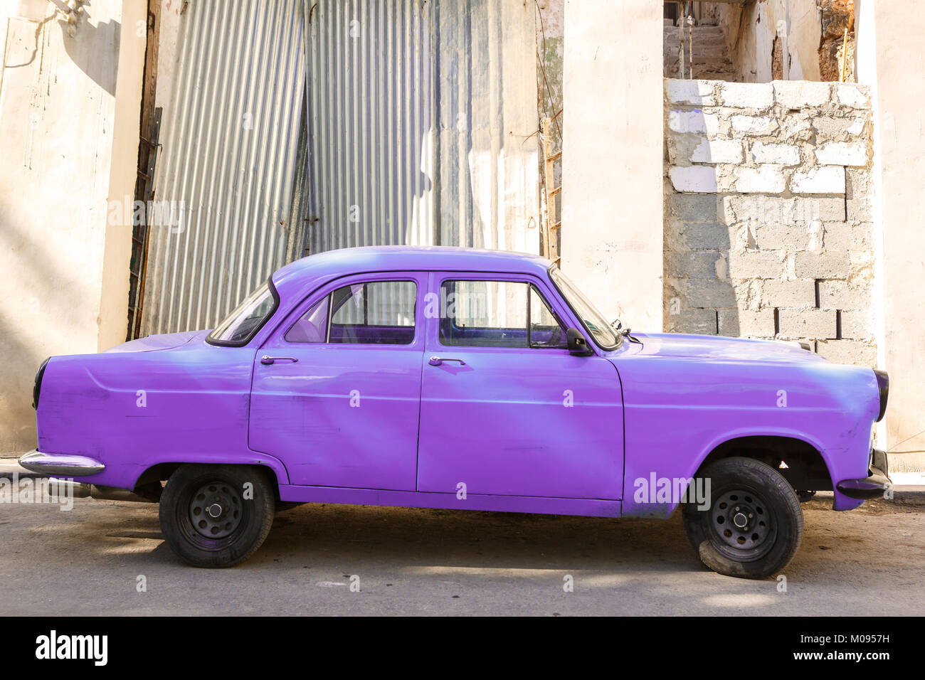 Vecchia auto viola parcheggiato su una strada in Cuba Foto Stock
