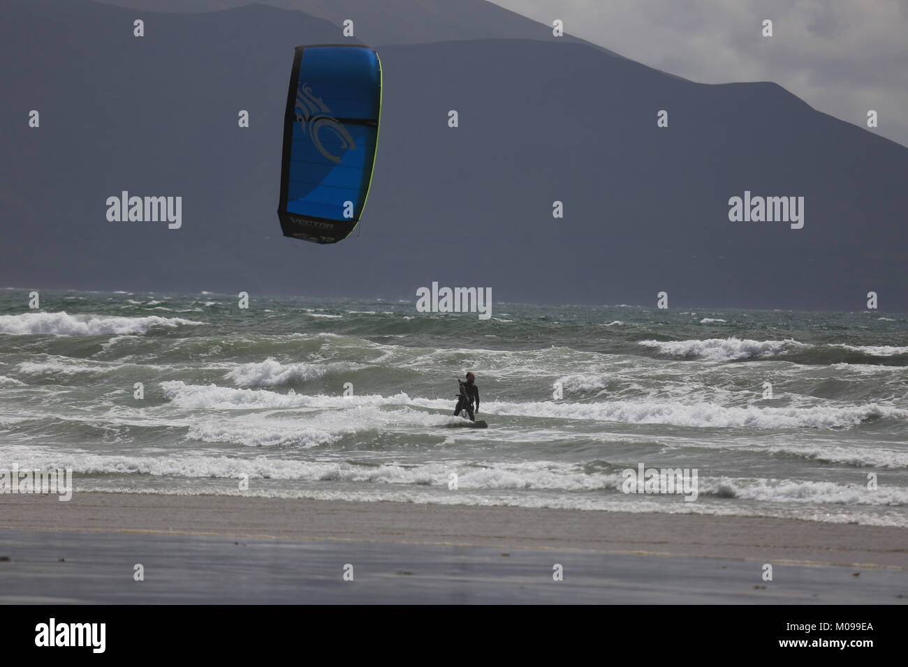 Surf e gioca con un aquilone su una spiaggia sul selvaggio modo atlantico Foto Stock