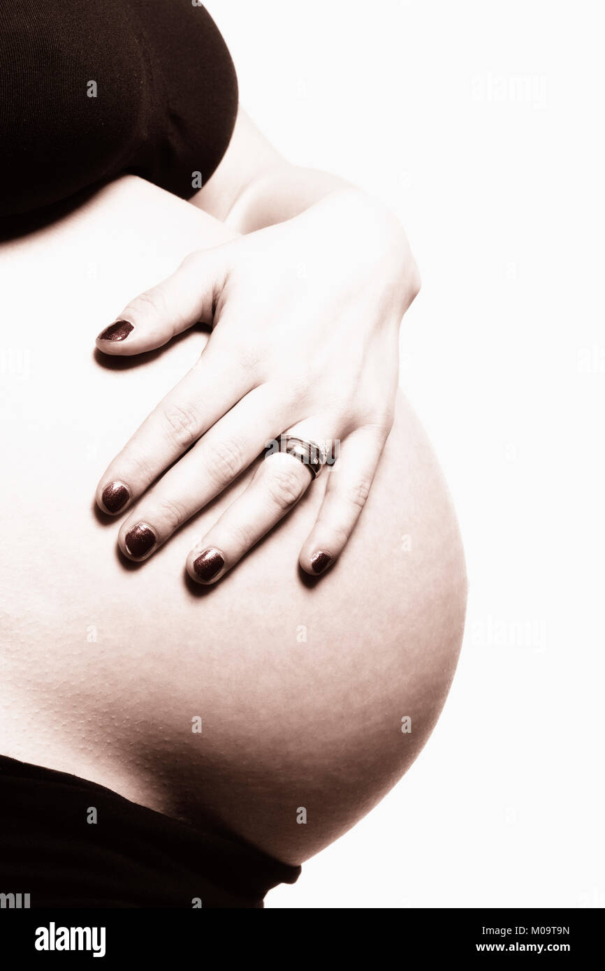 Dettaglio di un ventre della donna incinta nel reggiseno nero. Foto Stock