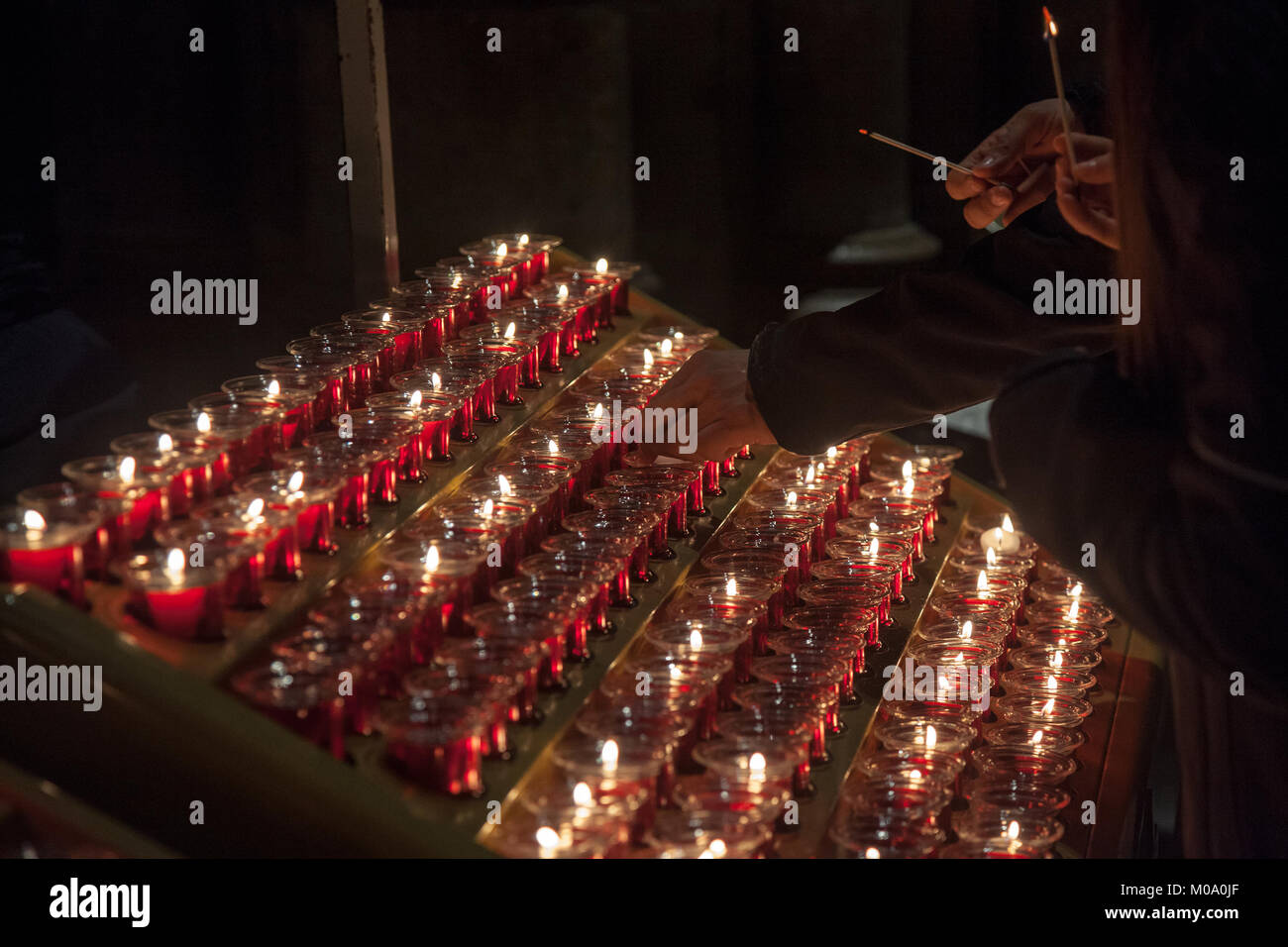 Persone accendendo candele nella cattedrale di Notre Dame di Parigi, Francia. Masterizzazione di una candela è una prassi usuale nel cattolicesimo per pregare. Foto di PEO Foto Stock