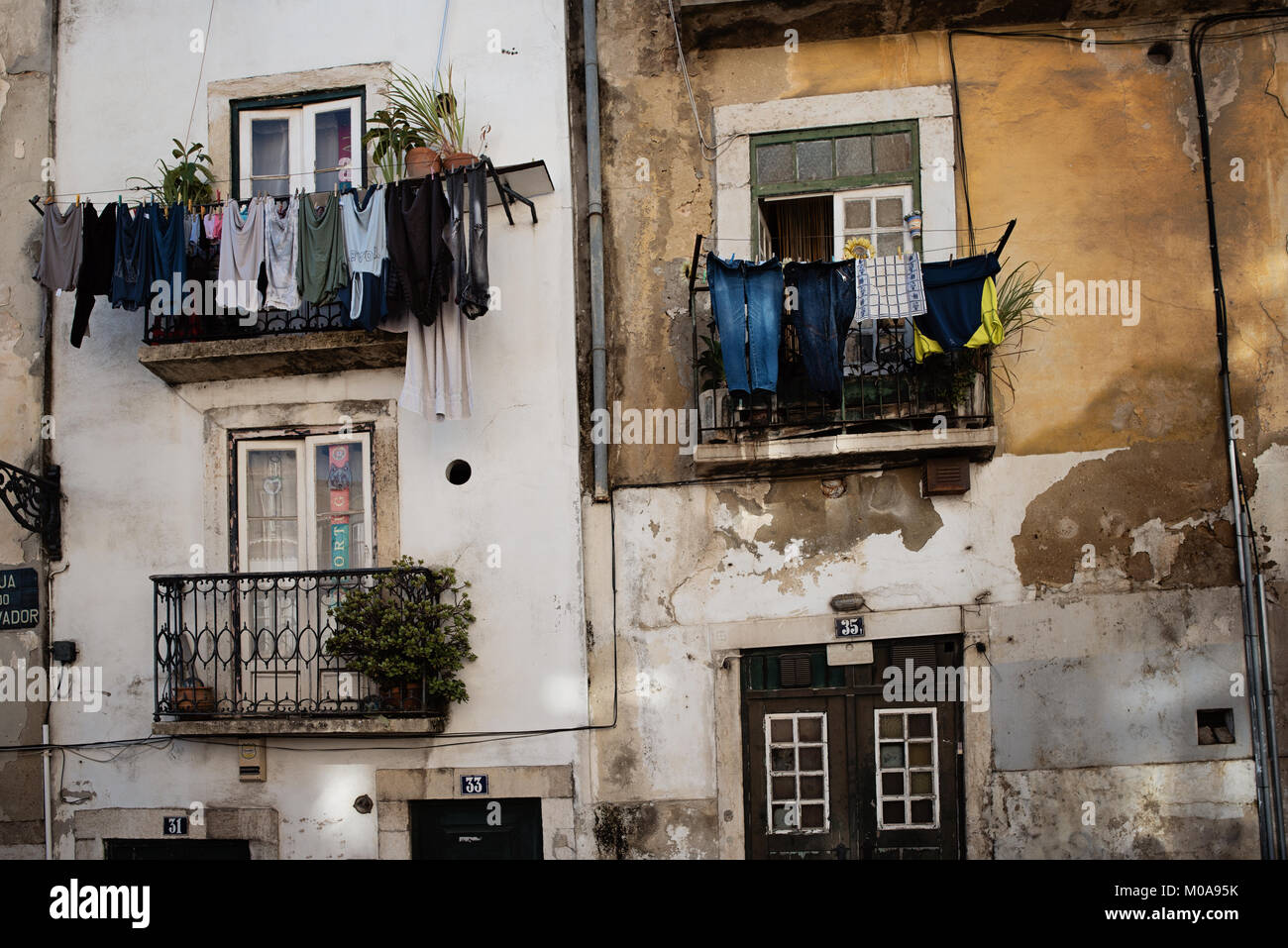 Facciata di vecchi edifici con lavanderia appesi per asciugare in Lisbona, Portogallo Foto Stock