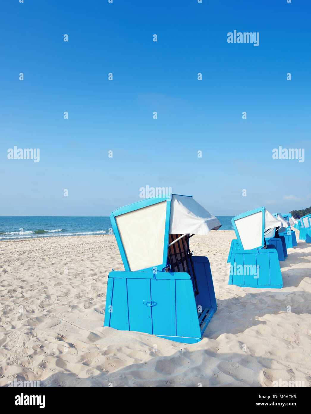 Spiaggia di sabbia e tradizionali in legno sedie da spiaggia su isola di Rügen, Germania settentrionale, sulla costa del Mar Baltico. Panorama, questa immagine è tonica. Foto Stock