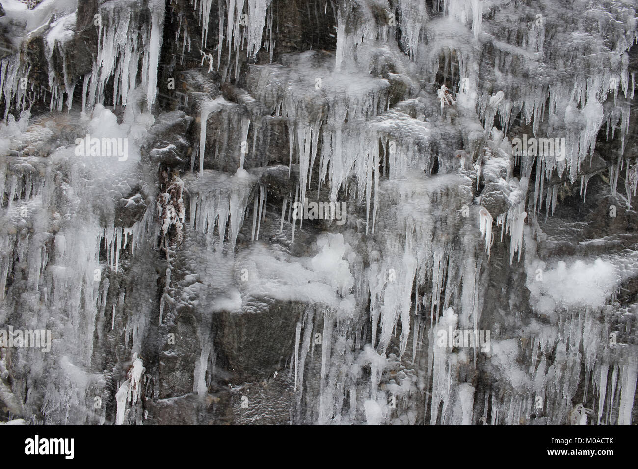 Immagine invernale di ghiaccio congelato o parete di roccia con ghiaccio falcetti. Foto Stock