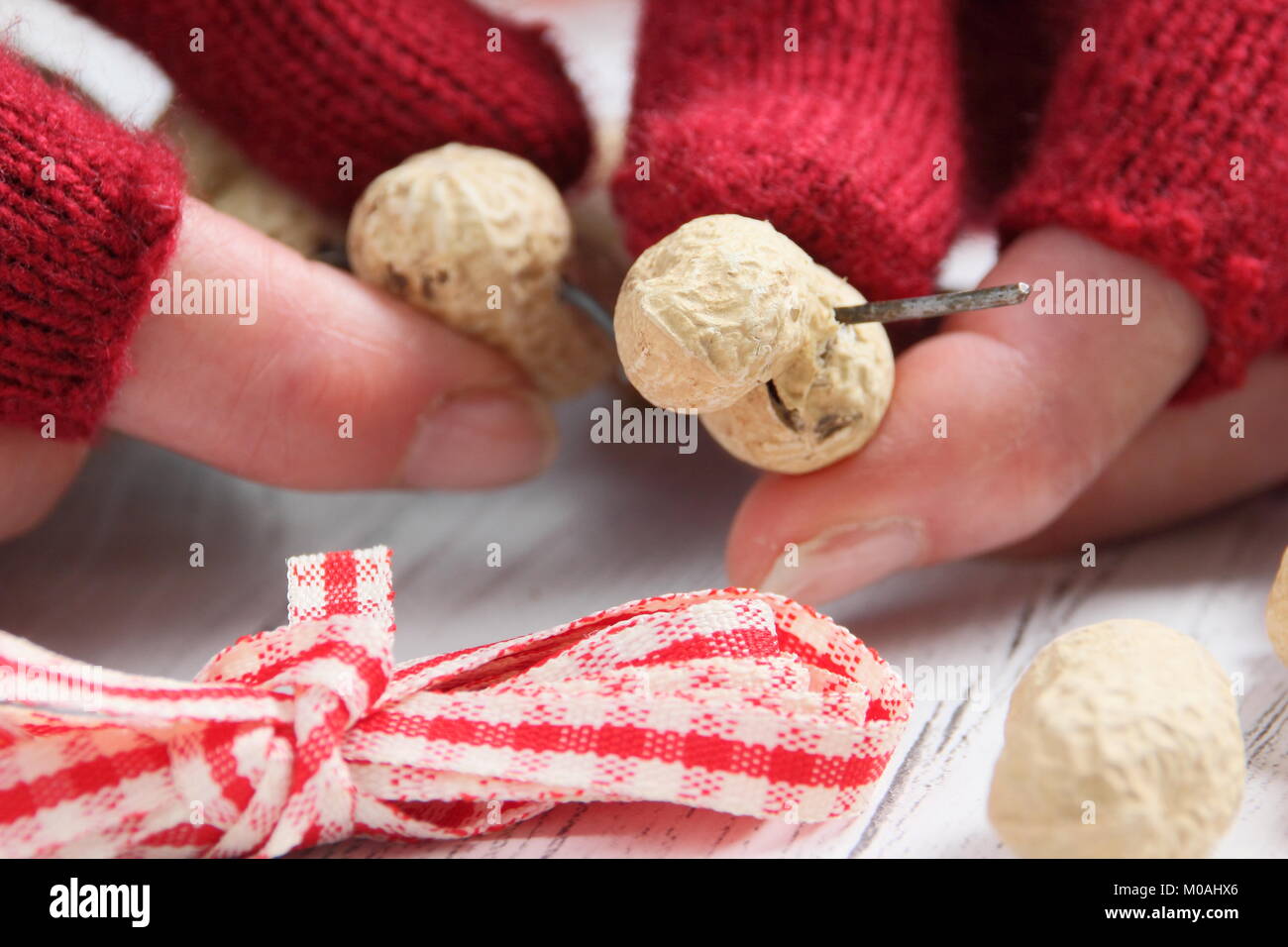 Creazione di una rapida, inverno a forma di cuore bird feeder da scimmia dadi (guida passo passo). Fase1/3: Thread monkey dadi sul filo artigianale modellata come cuore Foto Stock
