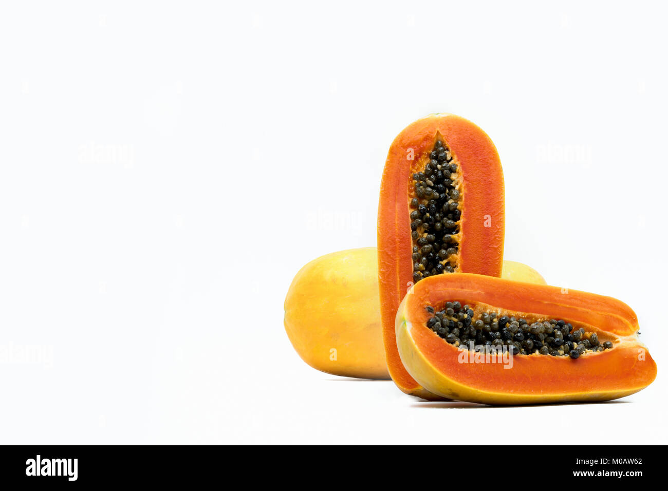 Intero e metà della papaia matura la frutta con semi isolato su sfondo bianco con copia spazio. Fonte naturale di vitamina C, acido folico e sali minerali. Un sano Foto Stock