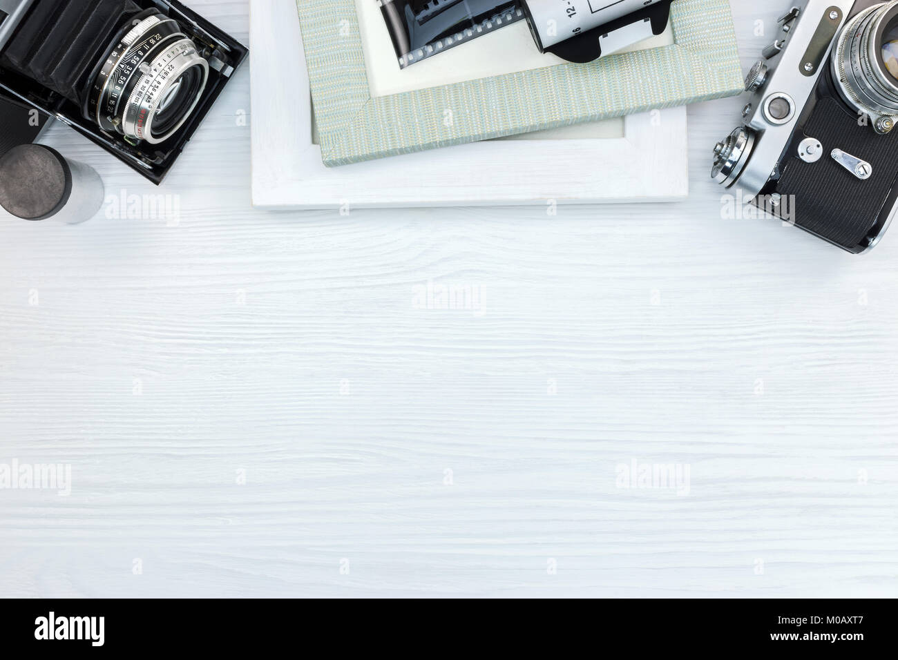 Retrò macchine fotografiche, pellicole negative e cornici per foto in bianco sullo sfondo di legno vista superiore Foto Stock